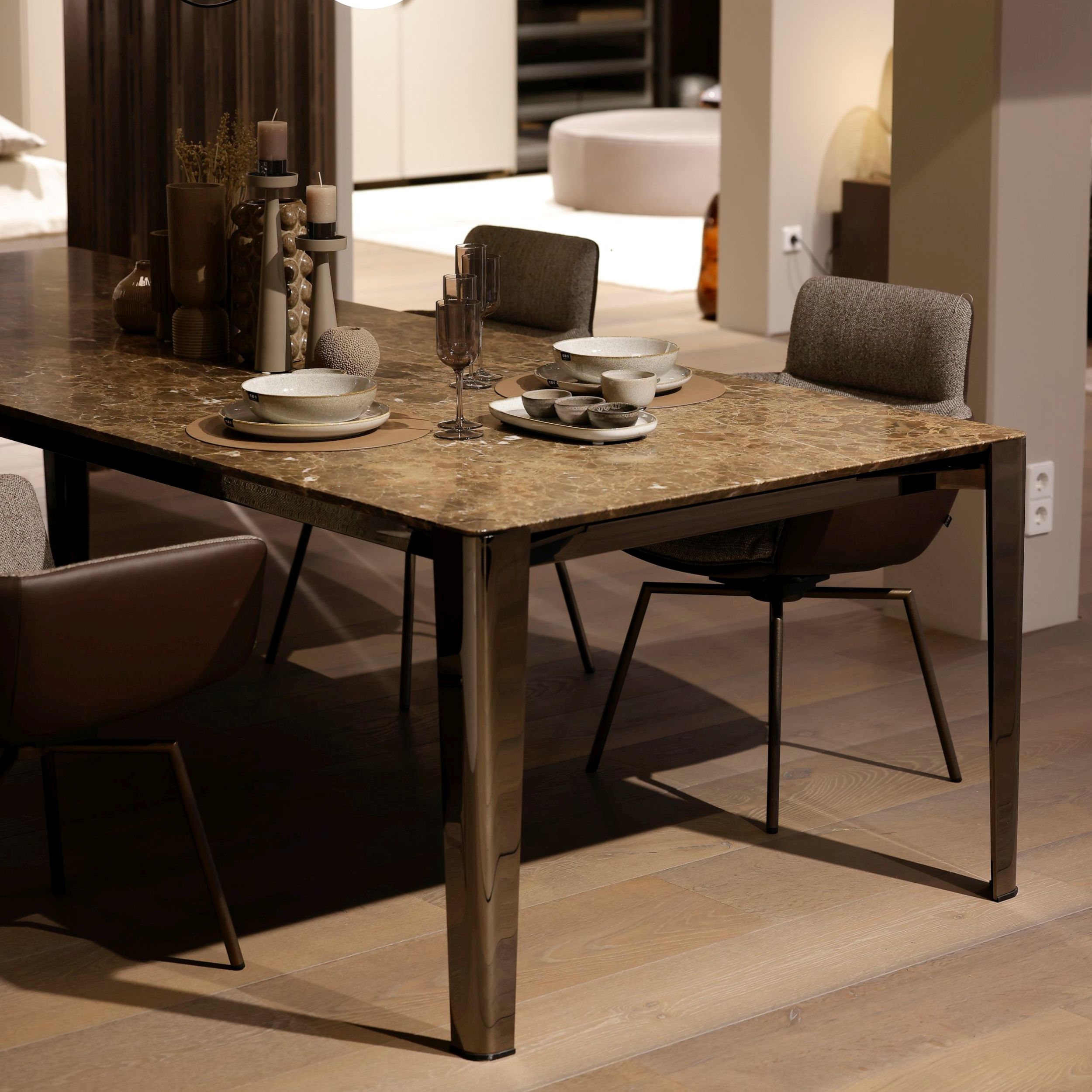 Rechteckiger Esstisch Iseo von Flexform mit brauner Marmorplatte und Schwarzchrom-Gestell elegant eingedeckt und kombiniert mit Armlehnstühlen von KFF.