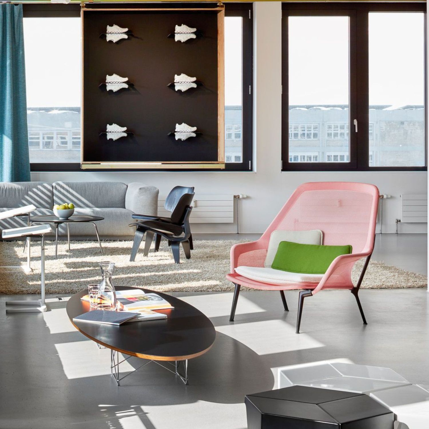 Slow Chair und Ottoman von Vitra in rosa Stricktex als Milieubild.