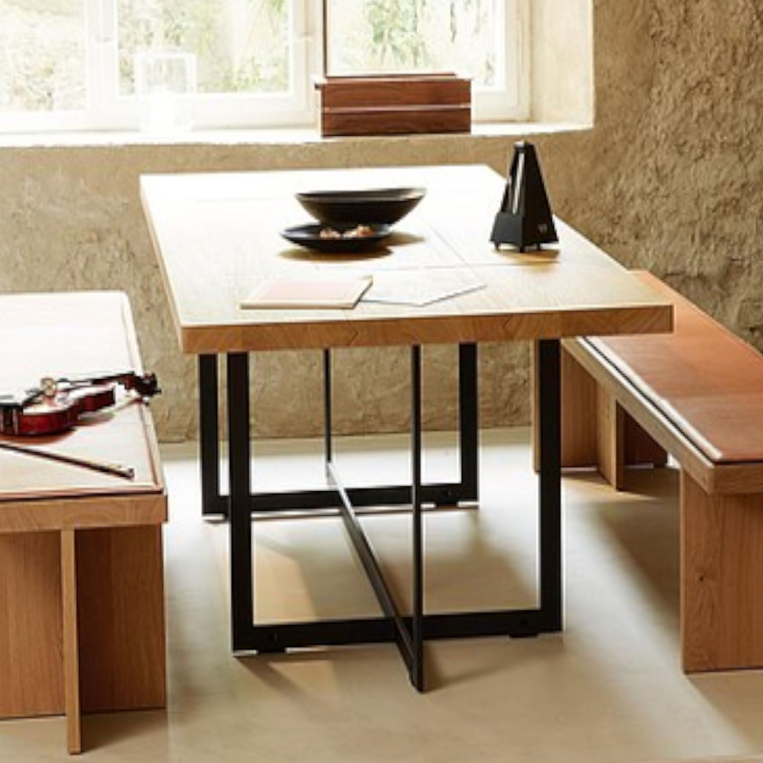 Zu sehen ist eine moderne Essgruppe B Solitaire von Bulthaup; derTisc hat eine massive Holzplatte und ein schwarzes Metallgestell.