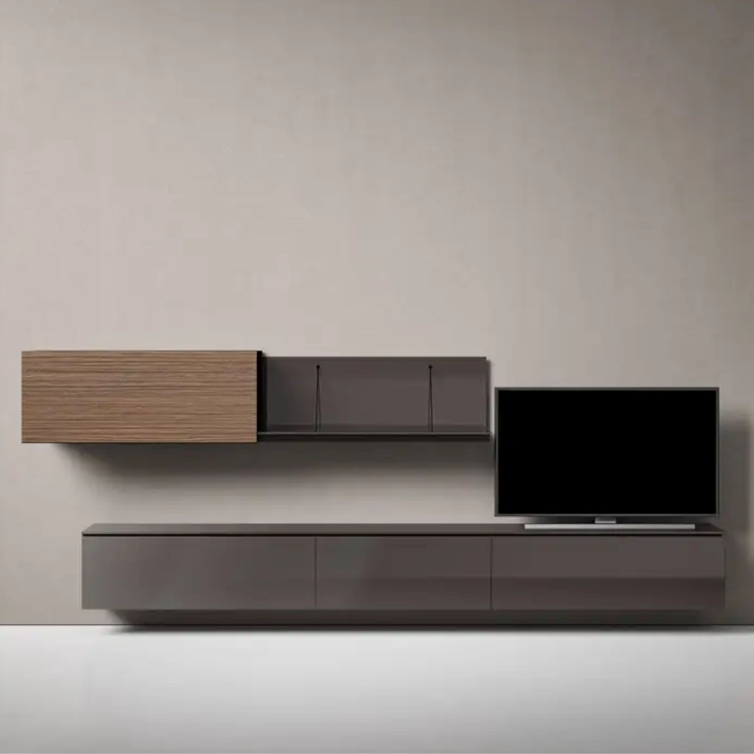 Das Bild zeigt die an einer grauen Wand hängende Wohnkombination Pab von B&B Italia, bestehend aus einem Lowboard in Lack Kaffee mit einem links darüber angeordneten Regalelement mit Schiebetür in Rosewood; rechts auf dem Lowboard steht ein Fernseher.