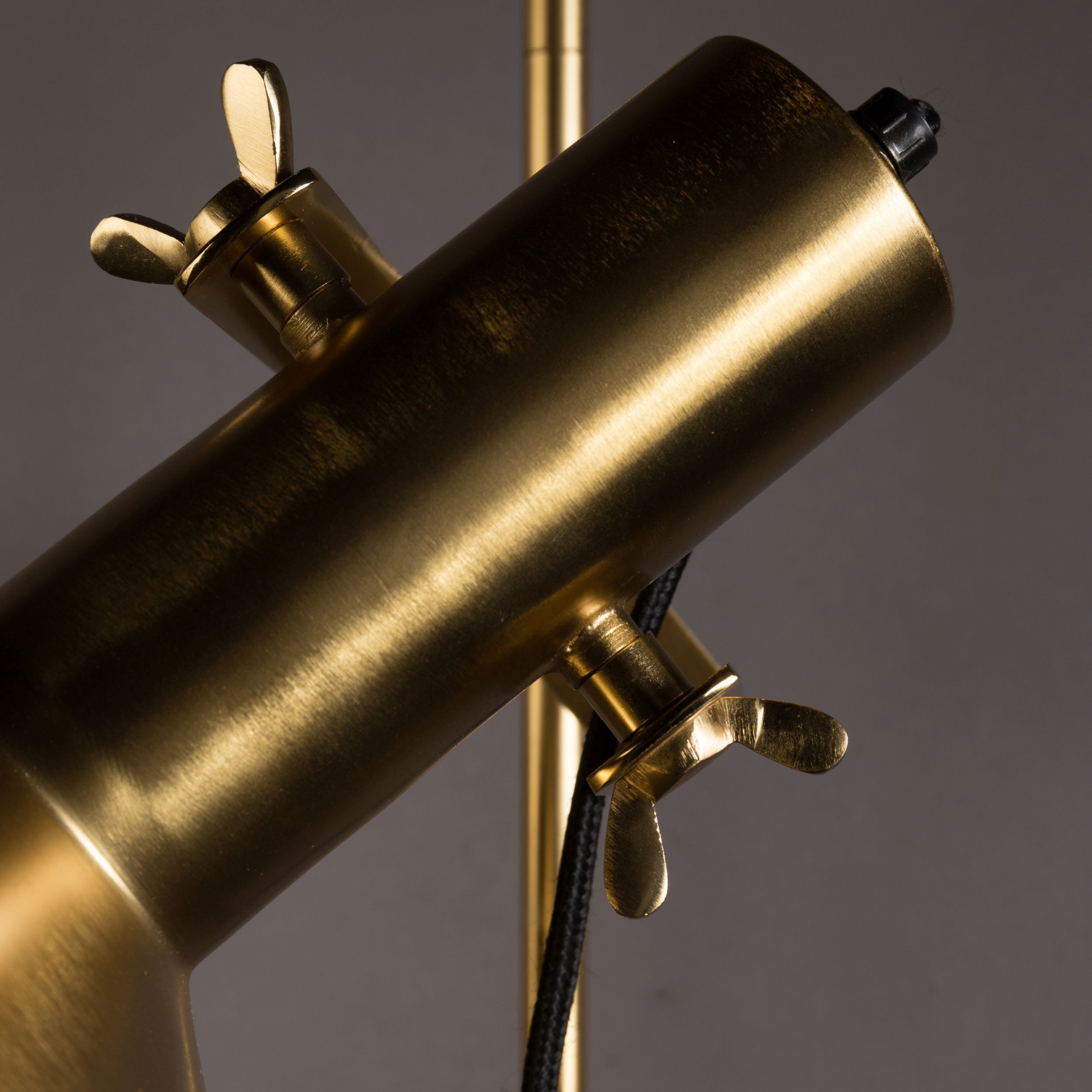 Detailansicht der Höhenverstellung einer goldenen Retro-Metallleuchte mit schwarzen Kabeldetails.