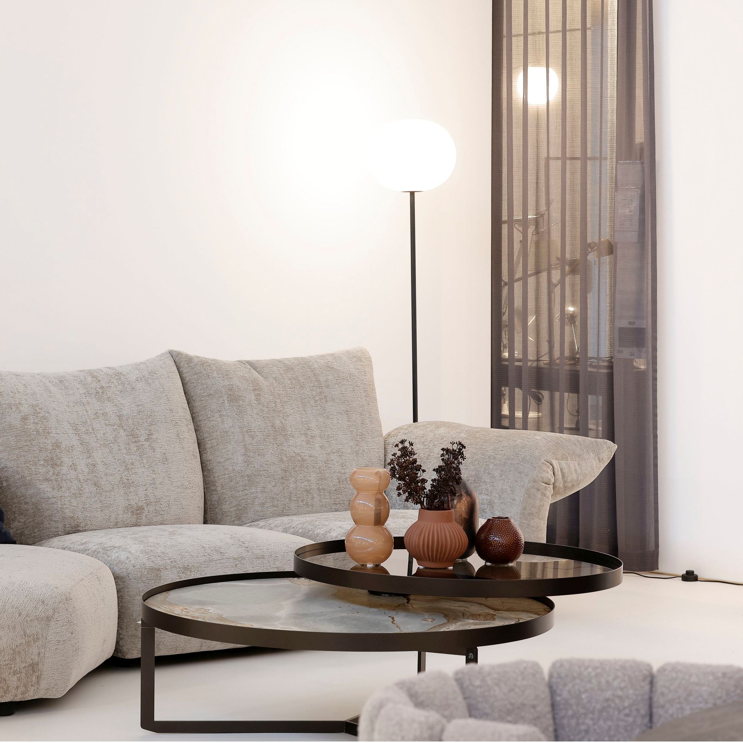 Zu sehen ist das Sofa Standard von Edra in einem eleganten Interieur in hellen Naturtönen. Das Bild zeigt die rechte Hälfte der Sofakombination, im Vordergrund steht ein Couchtisch mit Vasen im Rost-Tönen.