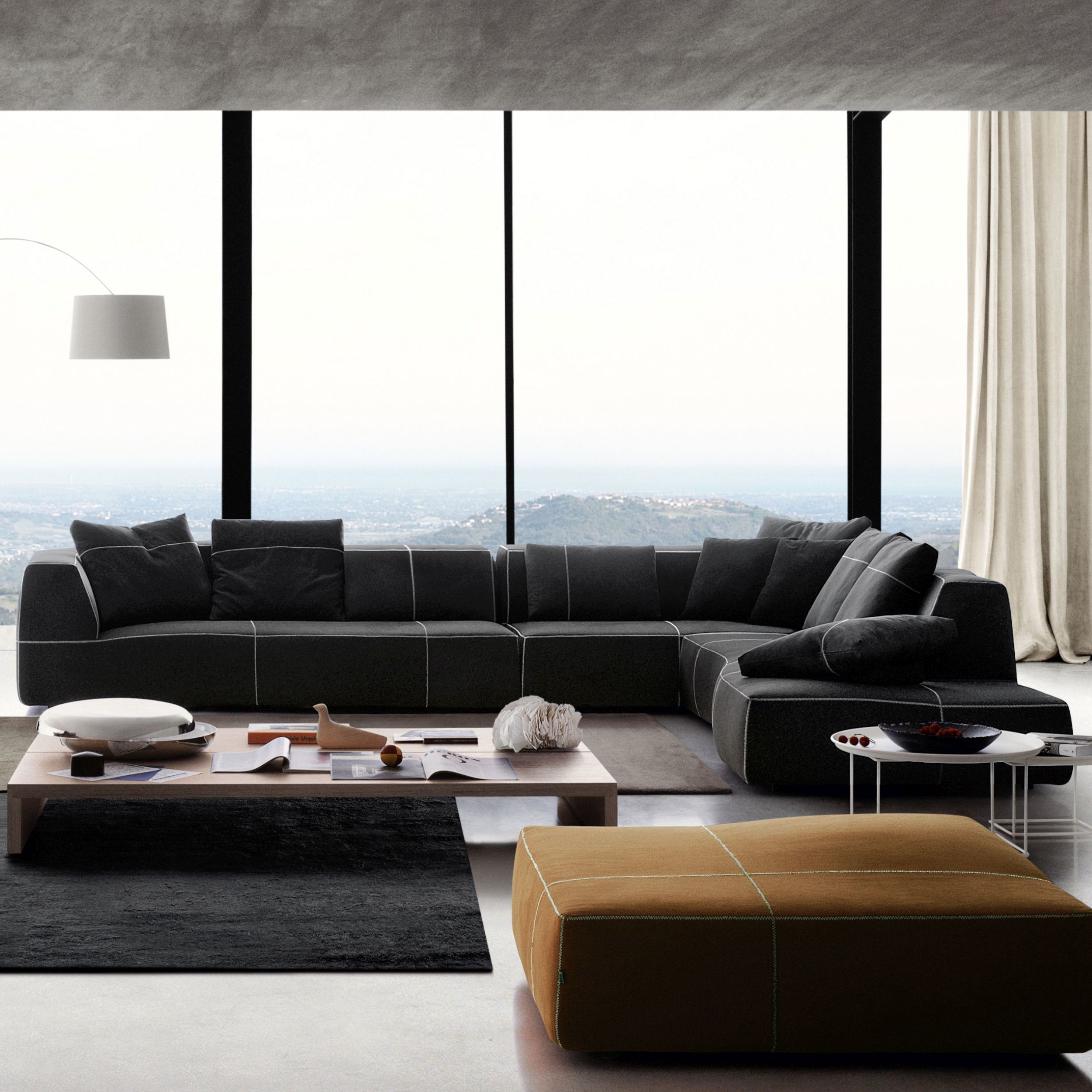 Heller Wohnbereich mit einem großen, modernen Ecksofa Bend von B&B Italia und einem minimalistischen Couchtisch.  