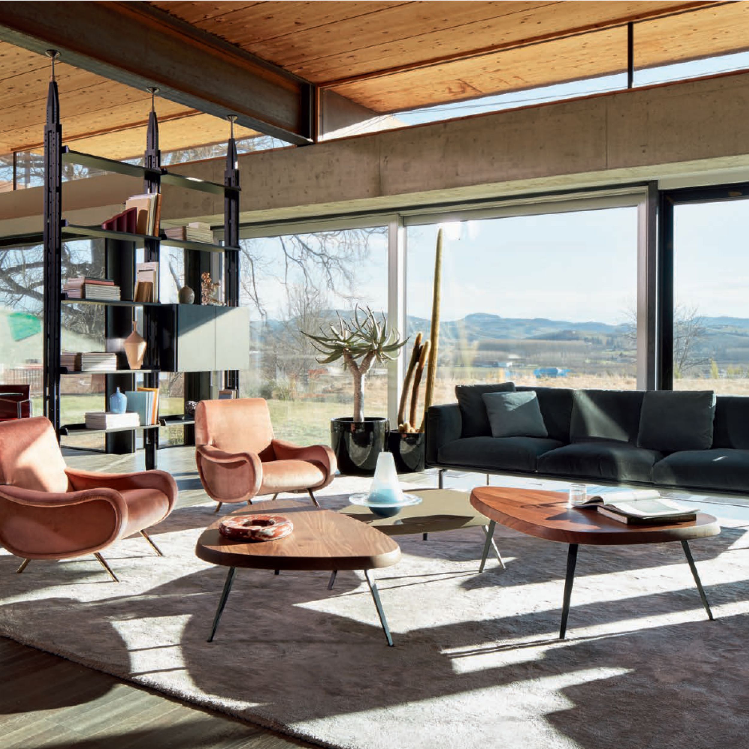 Lichtdurchflutetes Wohnzimmer mit zeitlos moderner Einrichtung und Panoramablick auf die Berge.
