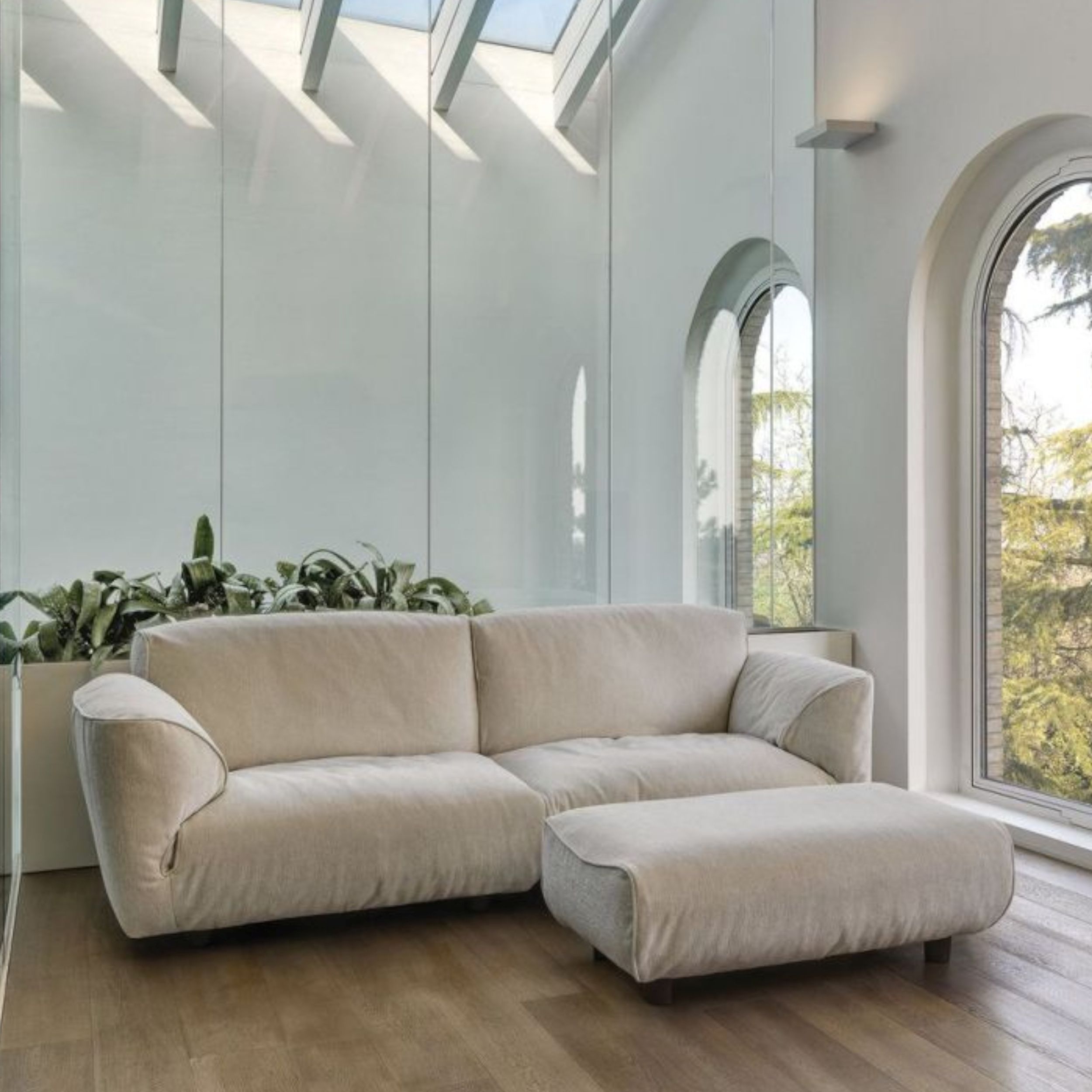 Sofa Grande Soffice von Edra als Zweisitzer mit Hocker in hellgrauem Stoff im Milieubild.