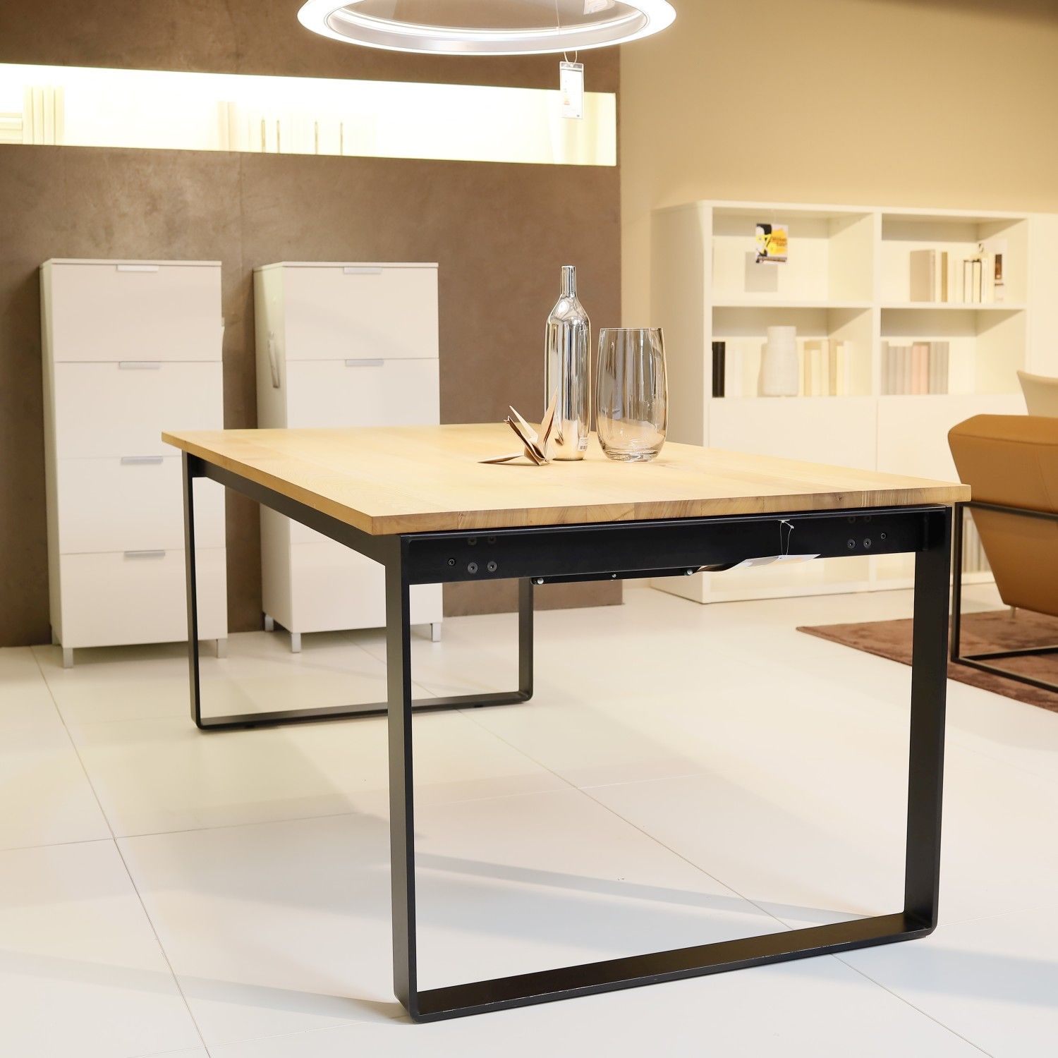 Zu sehen ist der Esstisch Infinity von Riva mit schwarzem Kufen-Unergestell und heller Holzplatte in einem modernen Esszimmer.