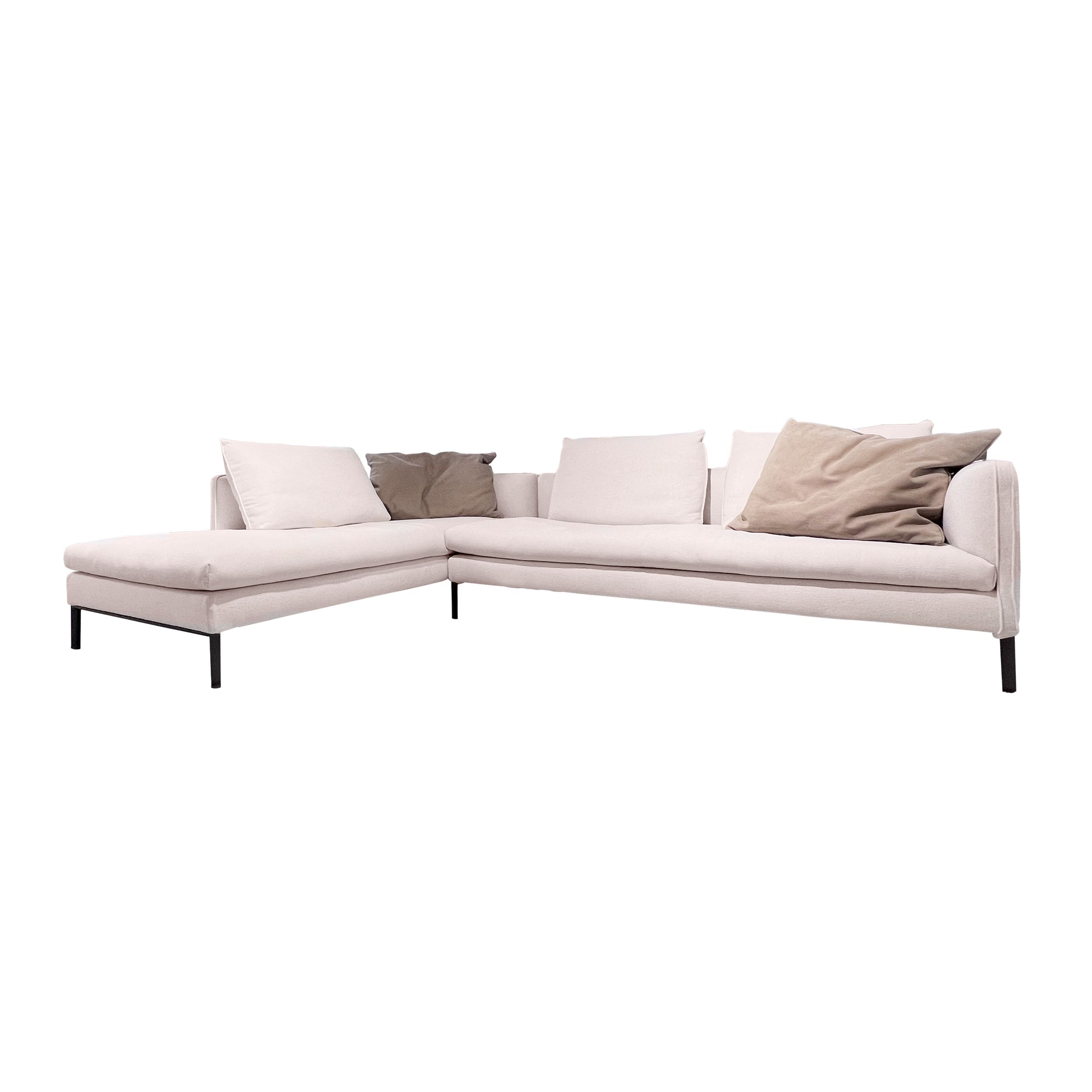 Sofa Paul von Molteni in weißem Stoff mit zwei braunen Leder-Dekokissen als Freisteller.