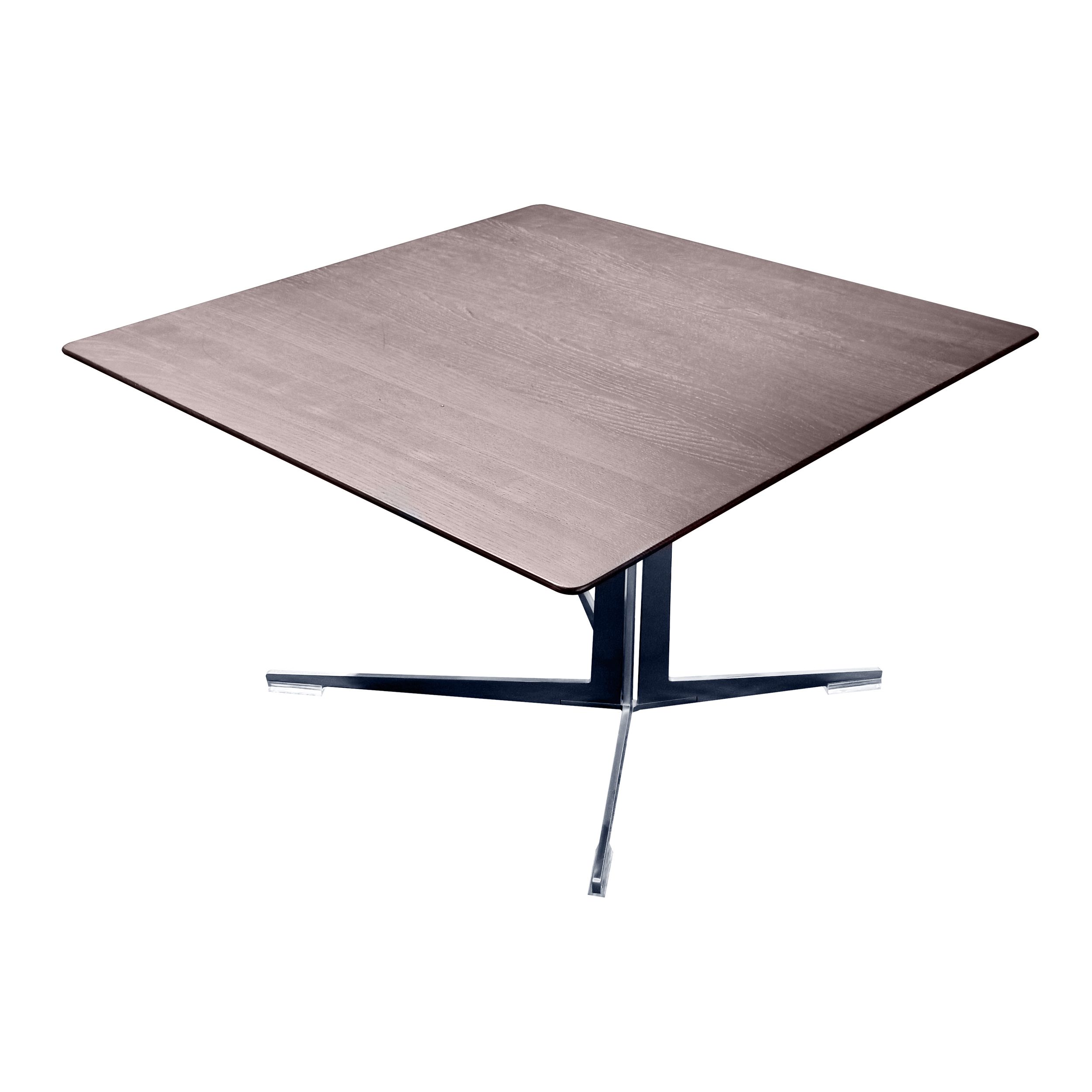 Ein quadratischer Couchtisch mit dunkler Holzplatte und sternförmigen Metallfuß, Modell Fly von Flexform, in Ansicht von schräg oben vor einem weißen Hintergrund.