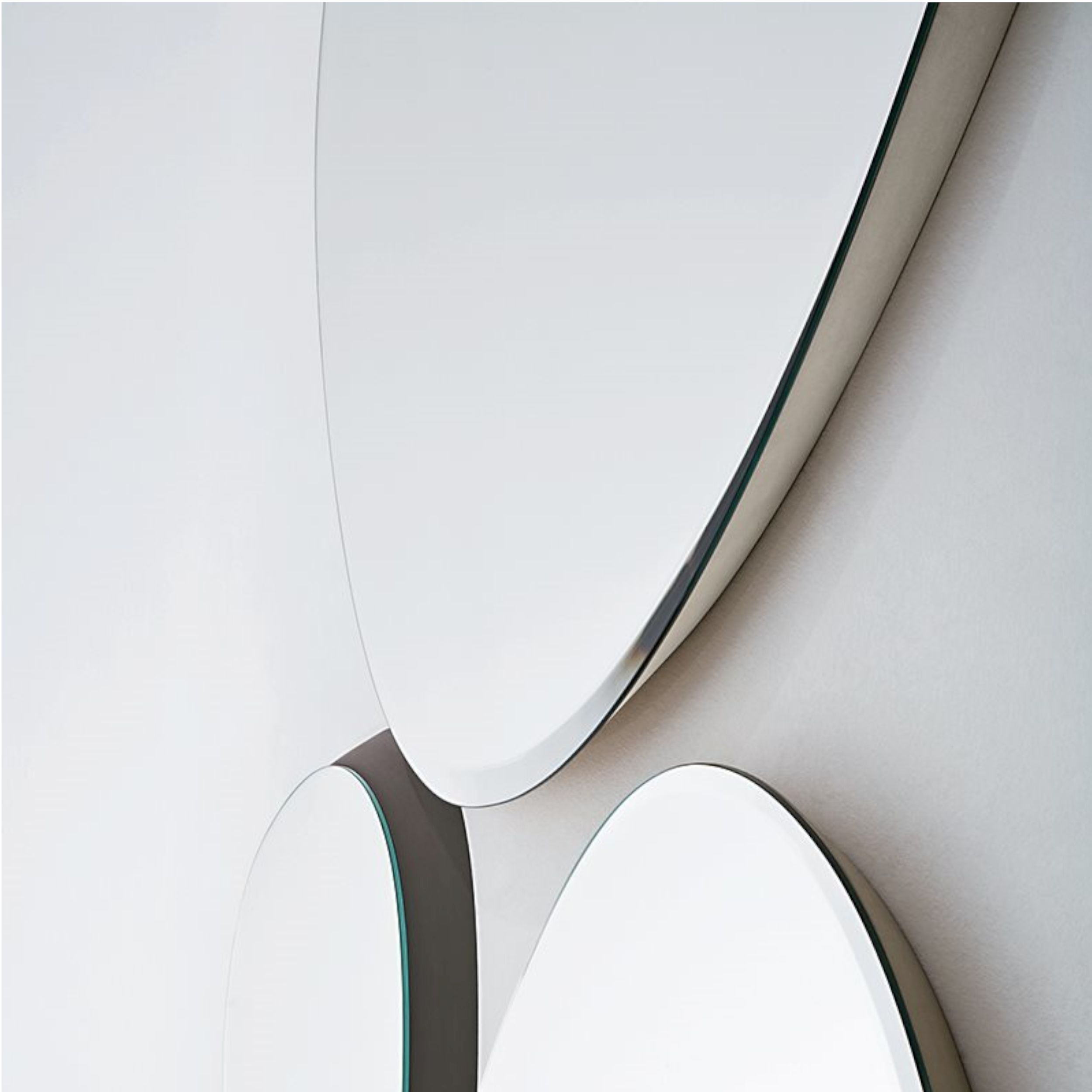 Seitliche Detailaufnahme von mehreren Spiegeln Modell Zeiss von Gallotti und Radice an einer weißen Wand.
