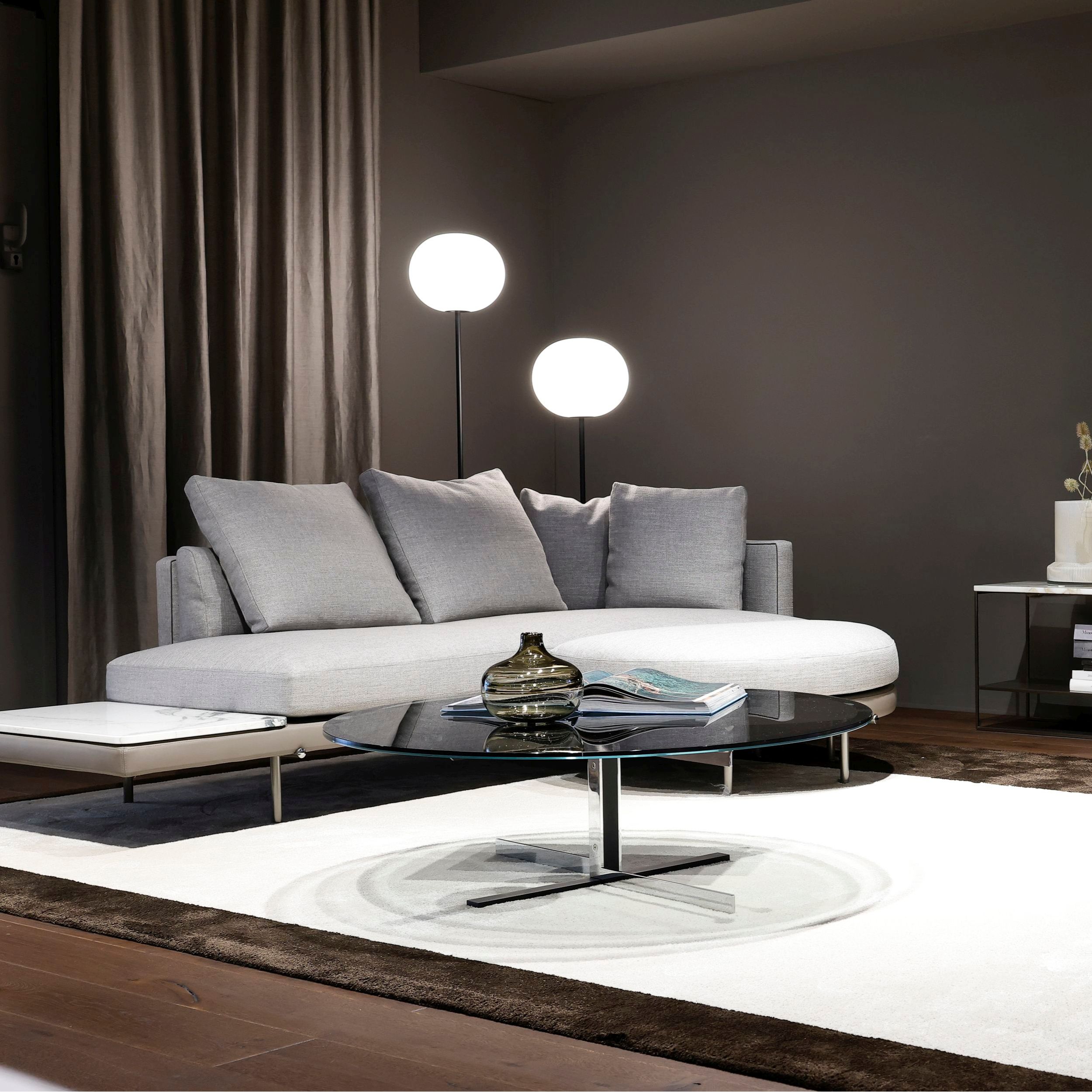 Couchtisch Catlin von Minotti mit Rauchglasplatte als Milieubild.