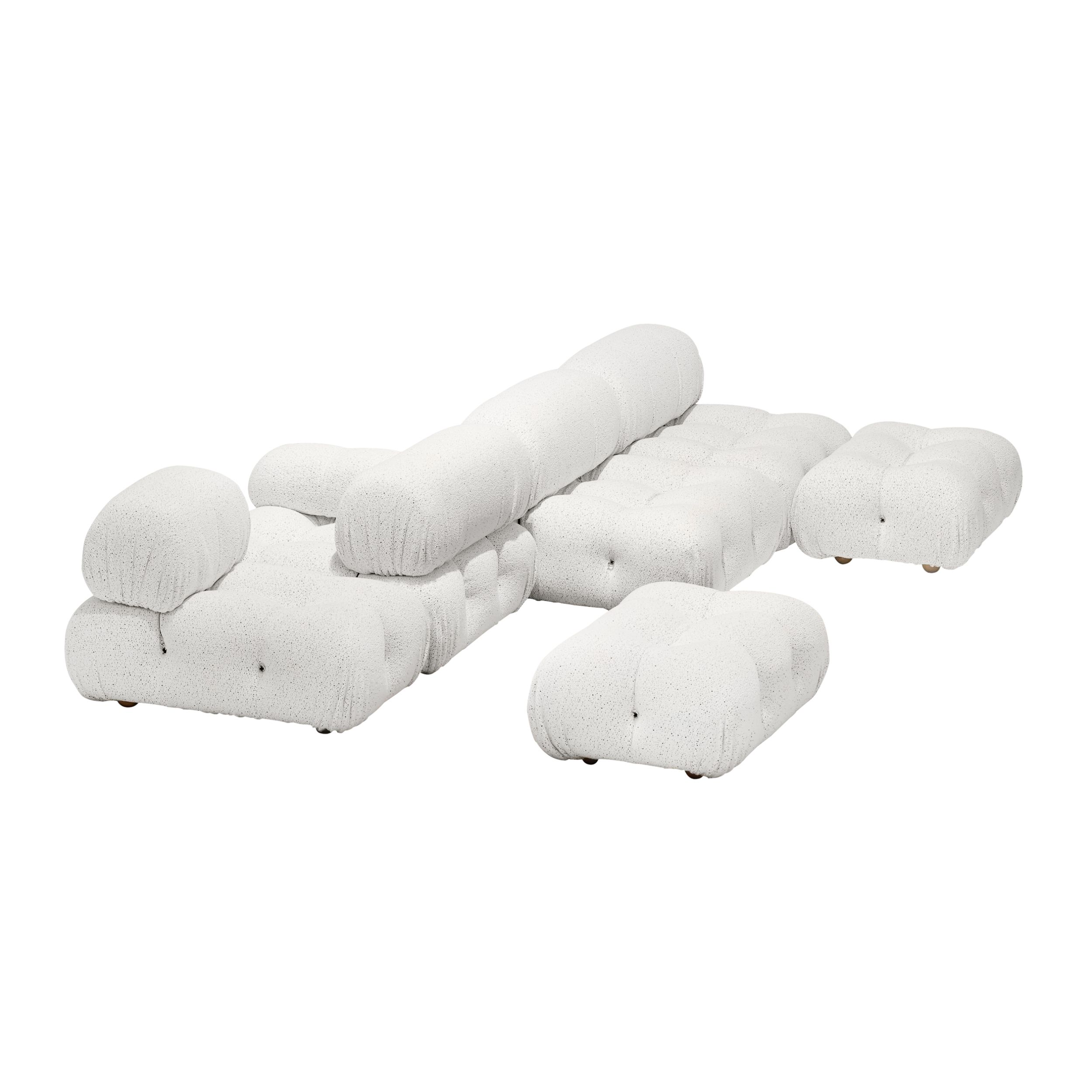 Auf dem Bild sieht man das Sofamodell Camaleonda von B&B Italia vor weißem Hintergrund. Gezeigt wird das Sofa mit einer Rückenlehne in der Mitte und rechts und links davon angeordneten Sitzflächen; im Vordergrund steht ein einzelner Hocker. Das Sofa ist m