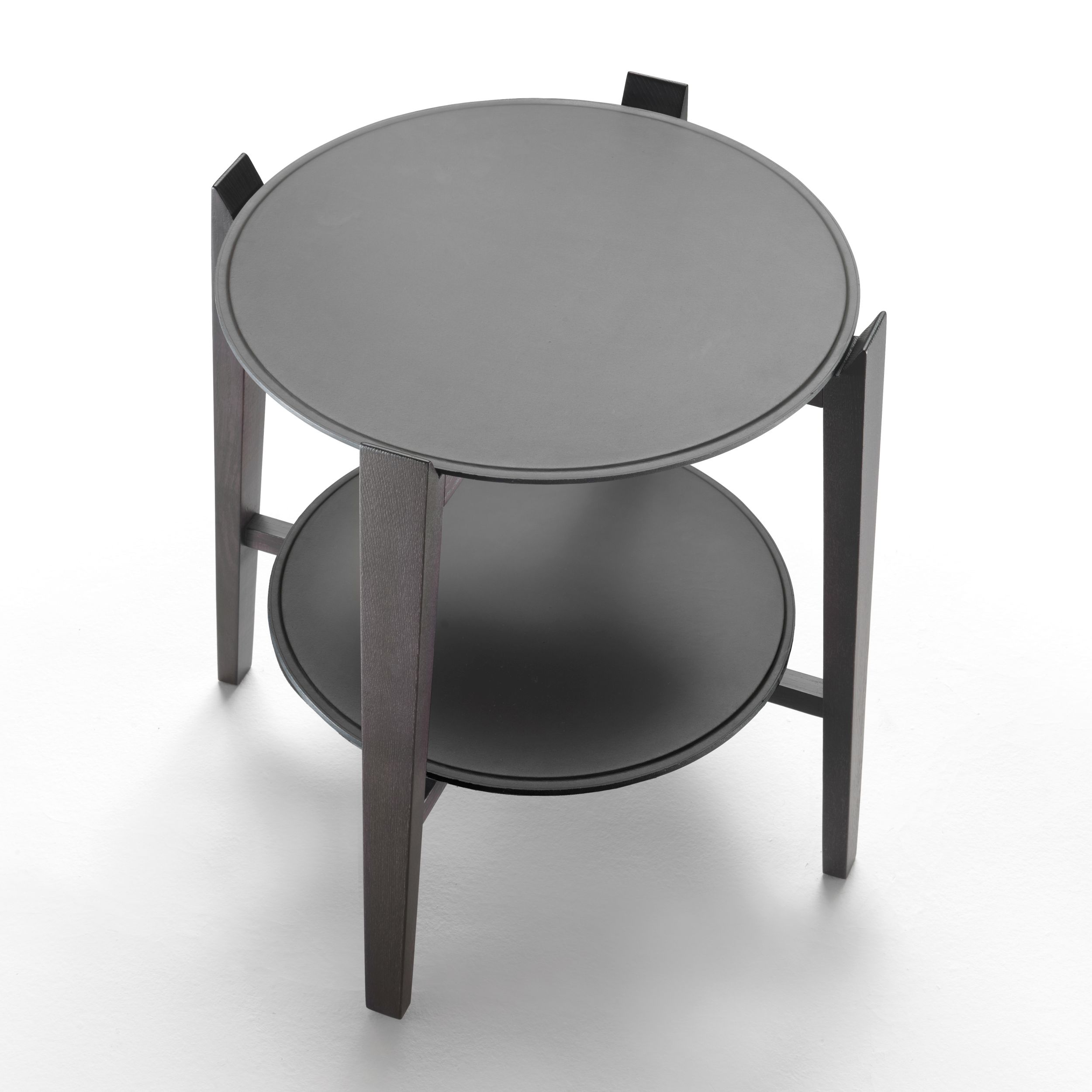 Ein runder Beistelltisch mit Holzgestell und Tischplatten aus Leder, Modell Cabaré von Flexform, in Ansicht von schräg oben vor einem weißen Hintergrund.