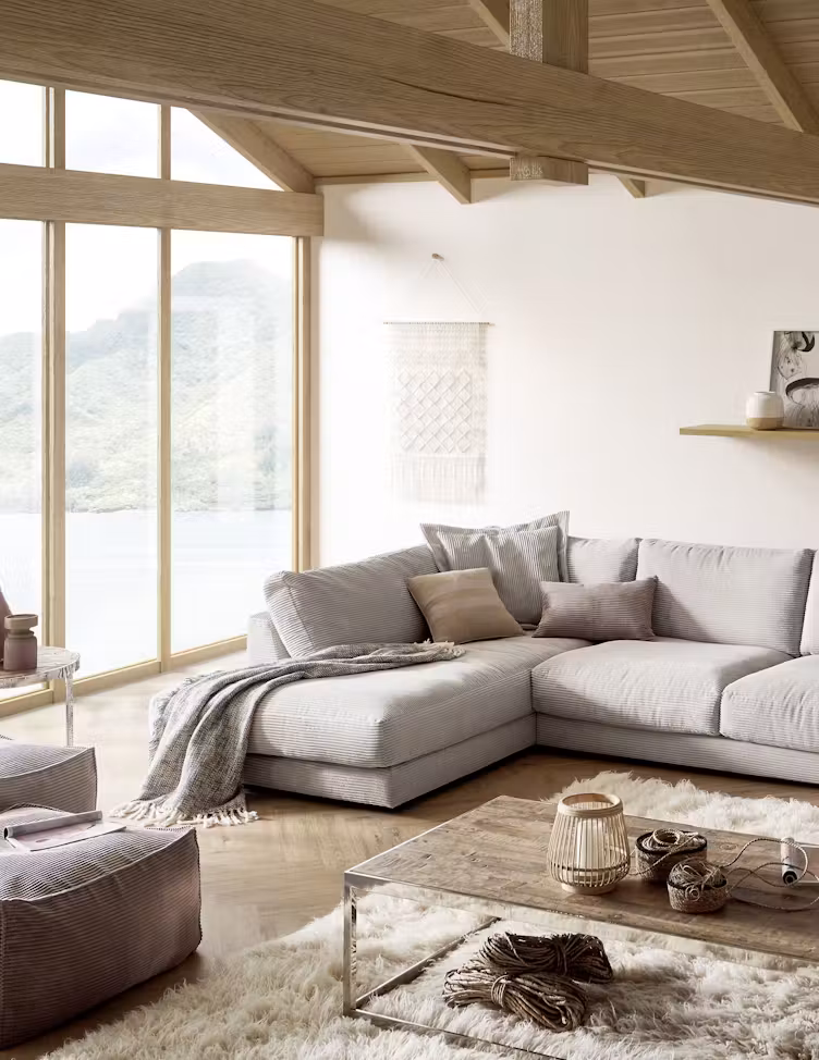 Helles Ecksofa mit Decke in einem Raum mit Dachschräge