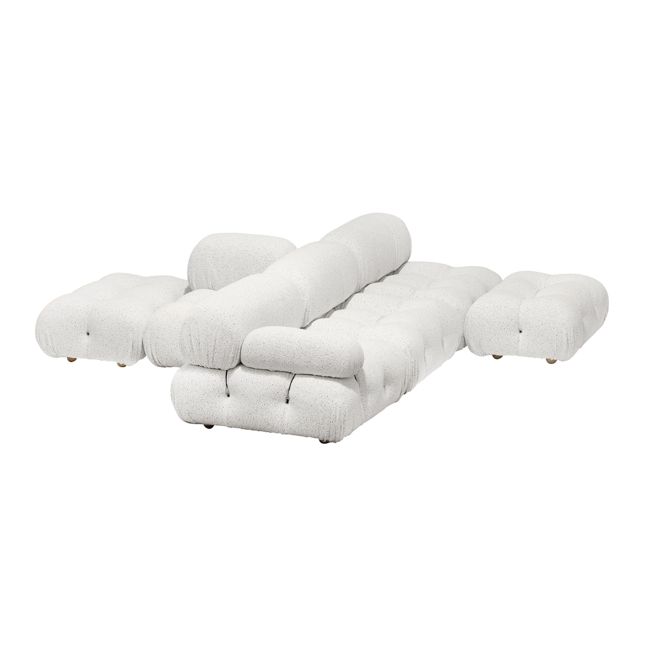 Auf dem Bild sieht man das modulare Sofamodell Camaleonda von B&B Italia vor weißem Hintergrund. Gezeigt wird das Sofa in einer  Zusammenstellung mit T-förmig Rückenlehnen in der Mitte und Sitzflächen rundherum. Das Sofa ist mit weißem Stoff bezogen.