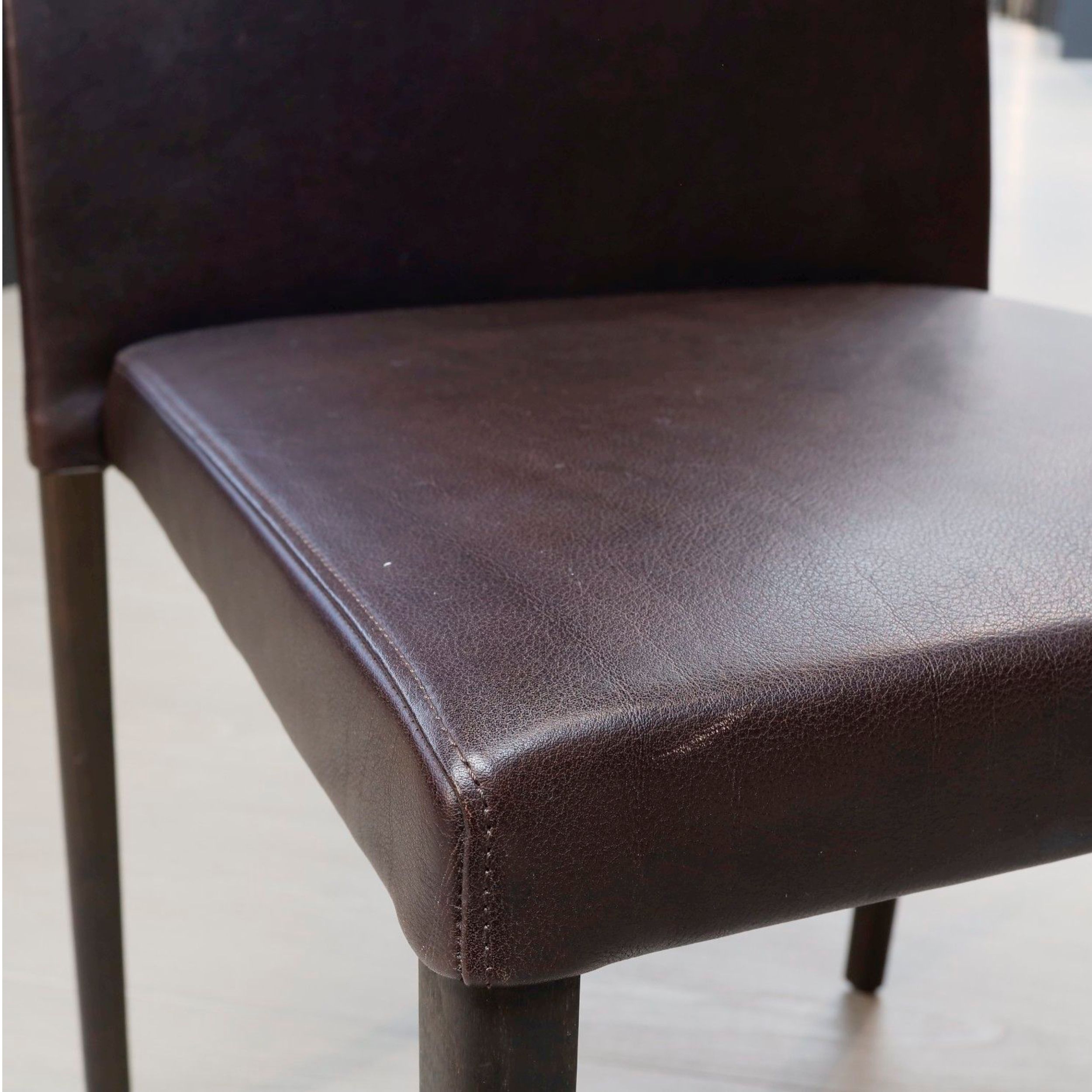 Esszimmerstuhl Jason Lite von Walter Knoll in braunem Leder mit Holzbeinen als Detailaufnahme.