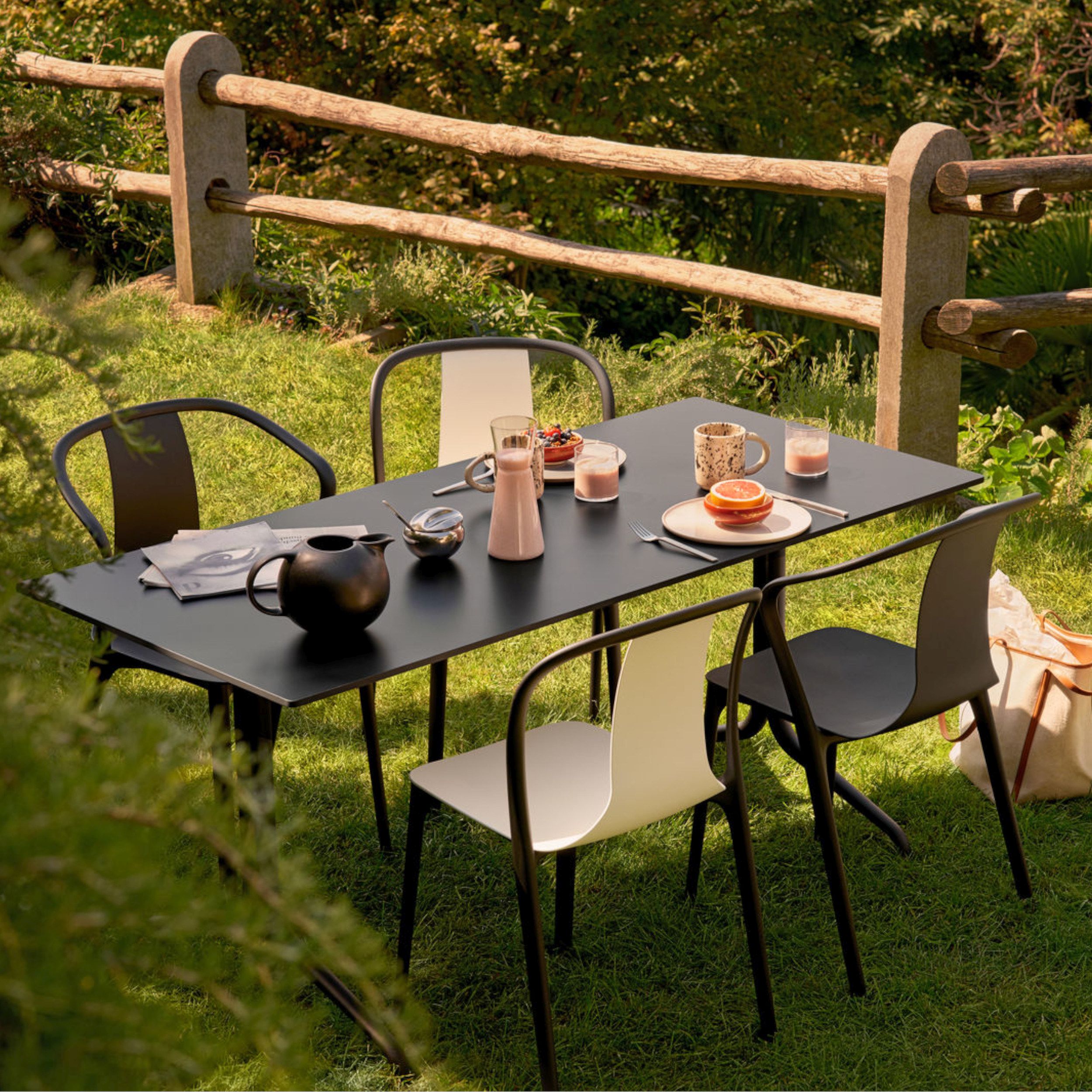 Stapelbarer Gartenstuhl Belleville Armchair aus schwarzem Kunststoff. Milieubild outdoor.