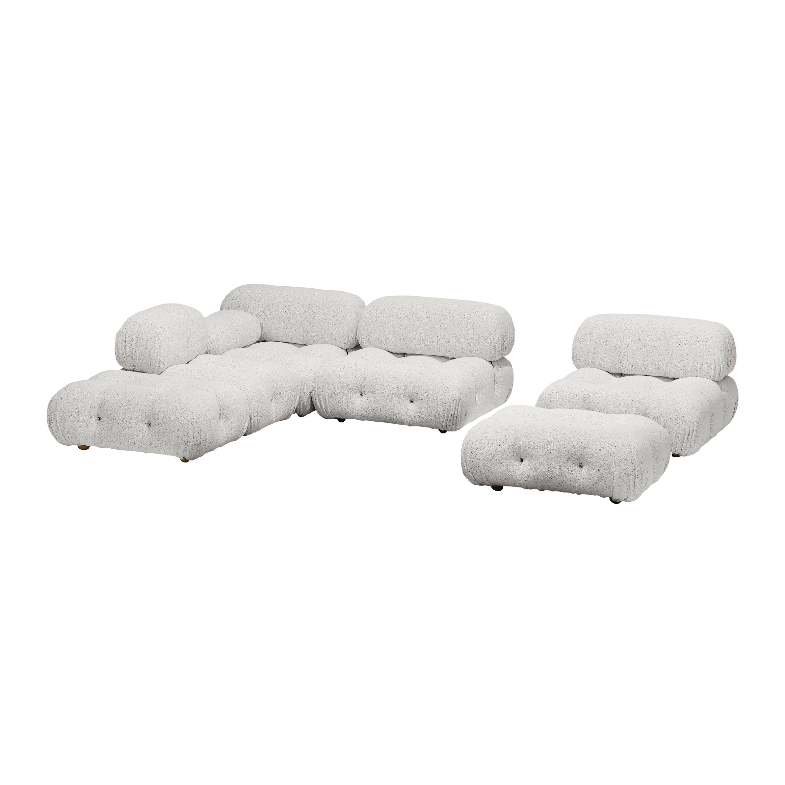 Auf dem Bild sieht man das modulare Sofamodell Camaleonda von B&B Italia vor weißem Hintergrund. Gezeigt wird eine Kombination aus einem L-förmigen Sofa und einem Einzelsitz mit davor stehendem Hocker. Das Sofa ist mit weißem Stoff bezogen.