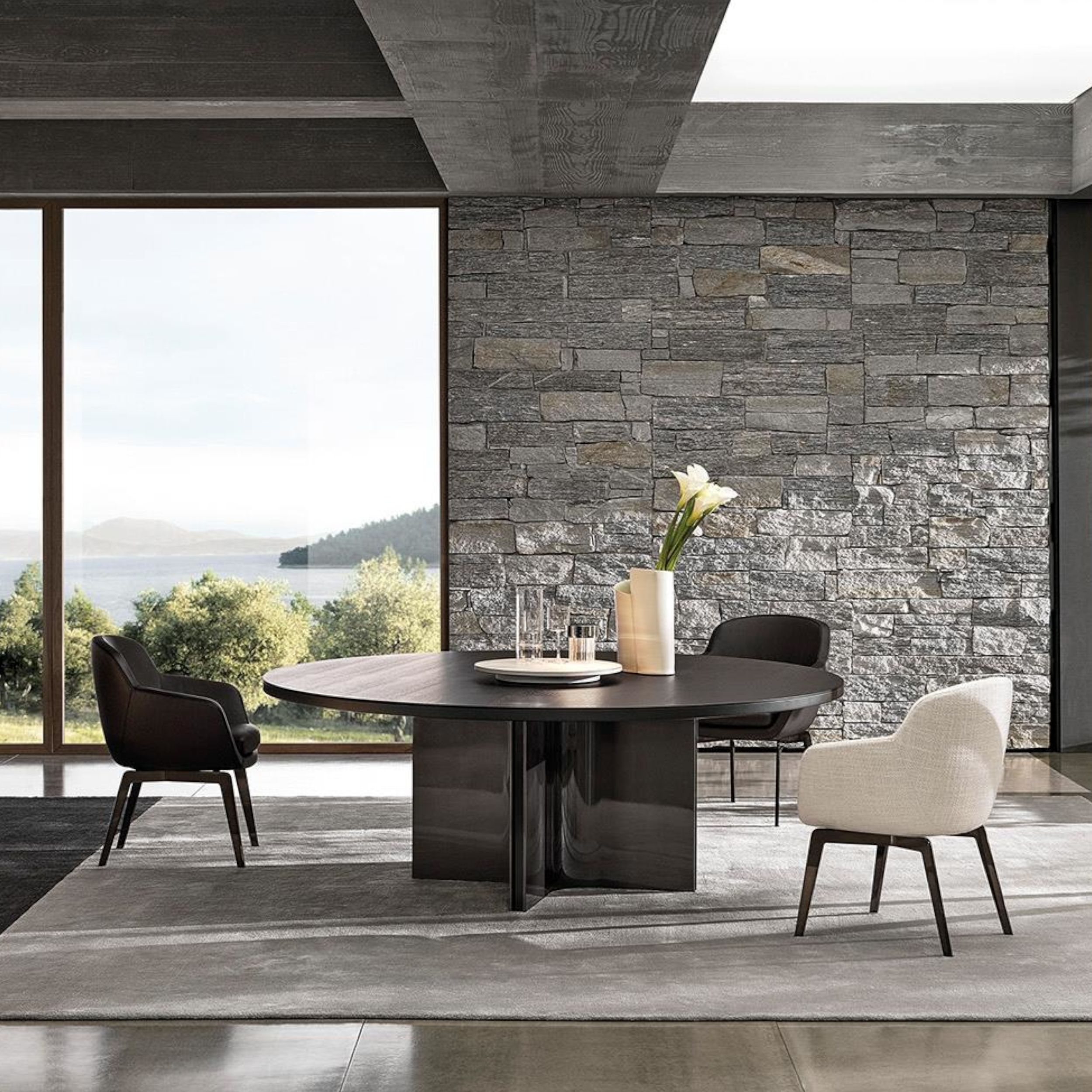 Schalenstuhl Belt von Minotti in verschiedenen Ausführungen in einem eleganten Interieur an einem runden Tisch.