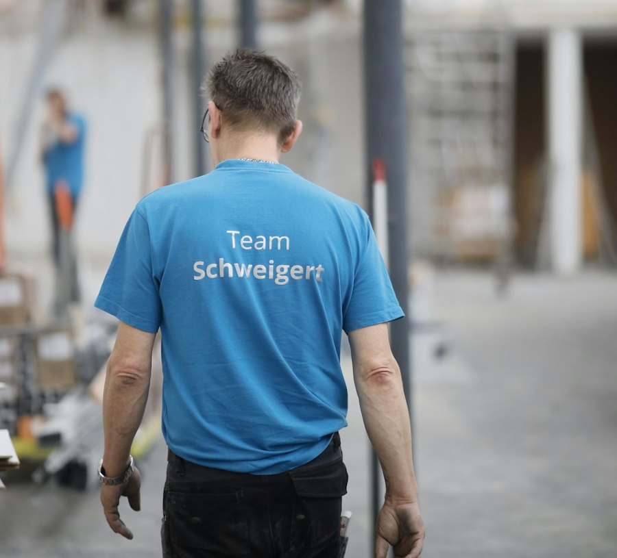 Mitarbeiter im blauen Team-Schweigert-Shirt von hinten in einem Raum im Umbau