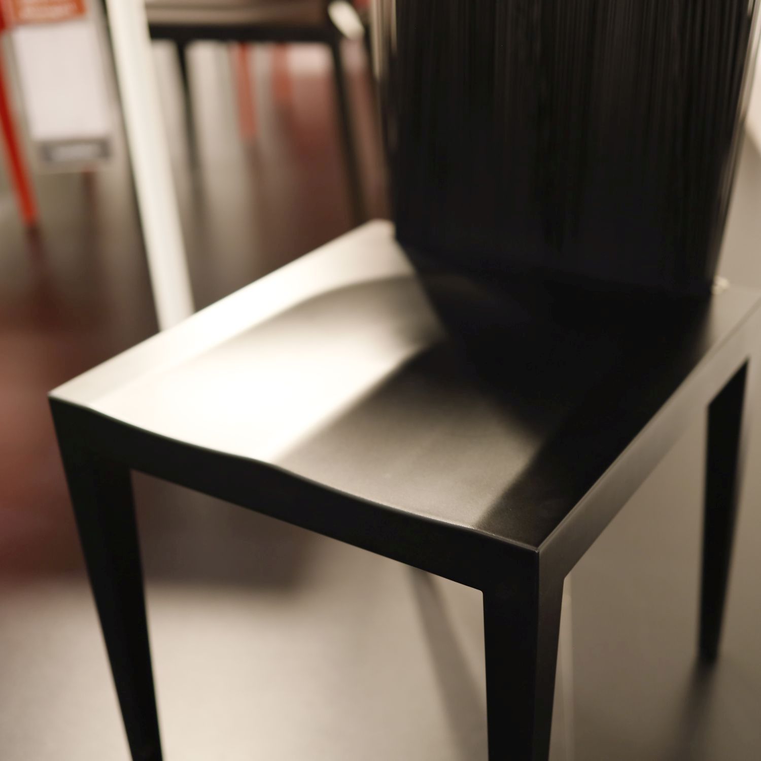 Das Bild zeigt in Detailaufnahme die schwarze Sitzfläche des Stuhlmodells Jenette von Edra.