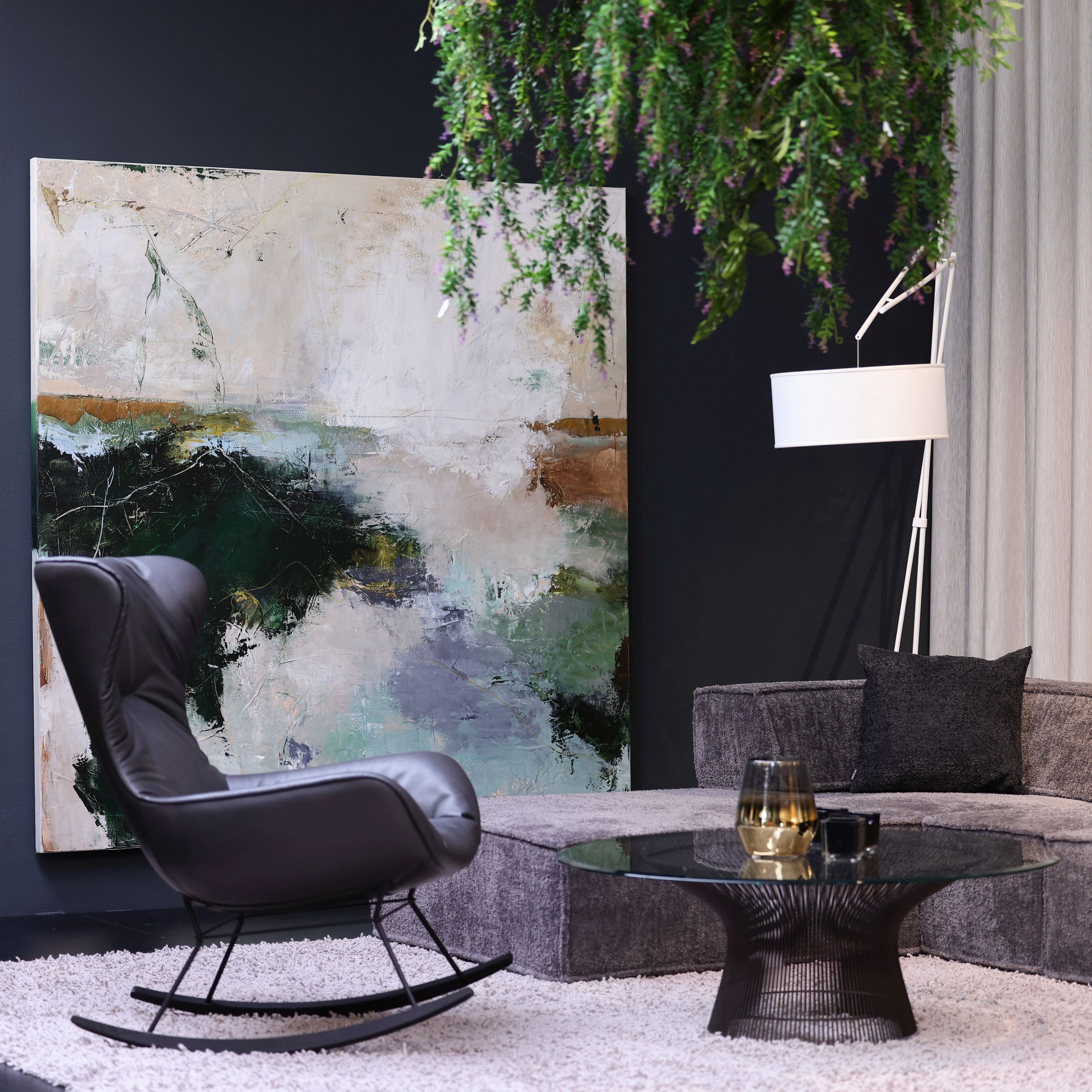 Ein eleganter Wohnraum mit dem Schaukelsessel Leya Rocking Wingback Chair vor einem  großformatigen abstrakten Gemälde.