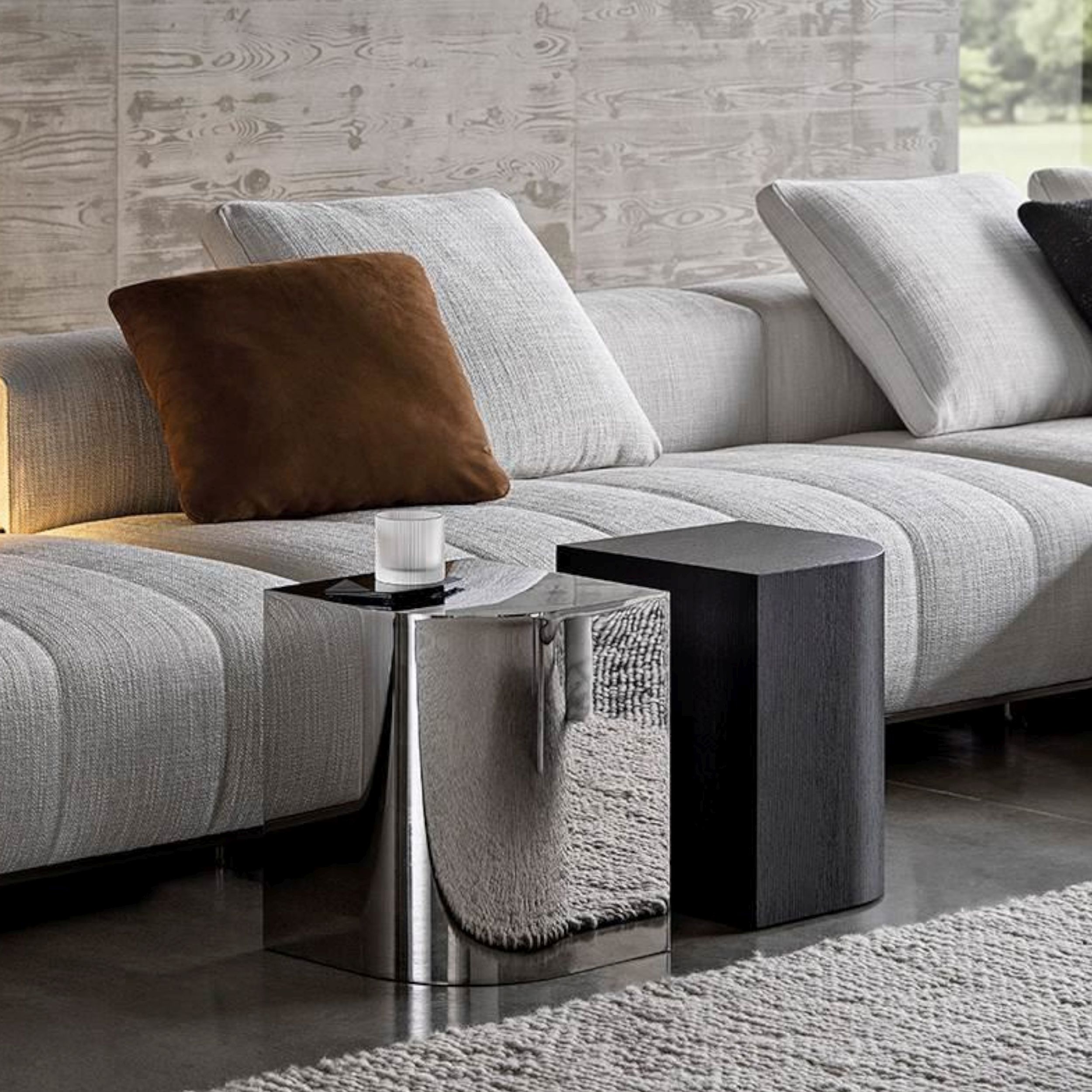 Stilvolles Wohnzimmer mit Couch, Couchtisch und Lampe, ergänzt mit Beistelltischen James von Minotti.  