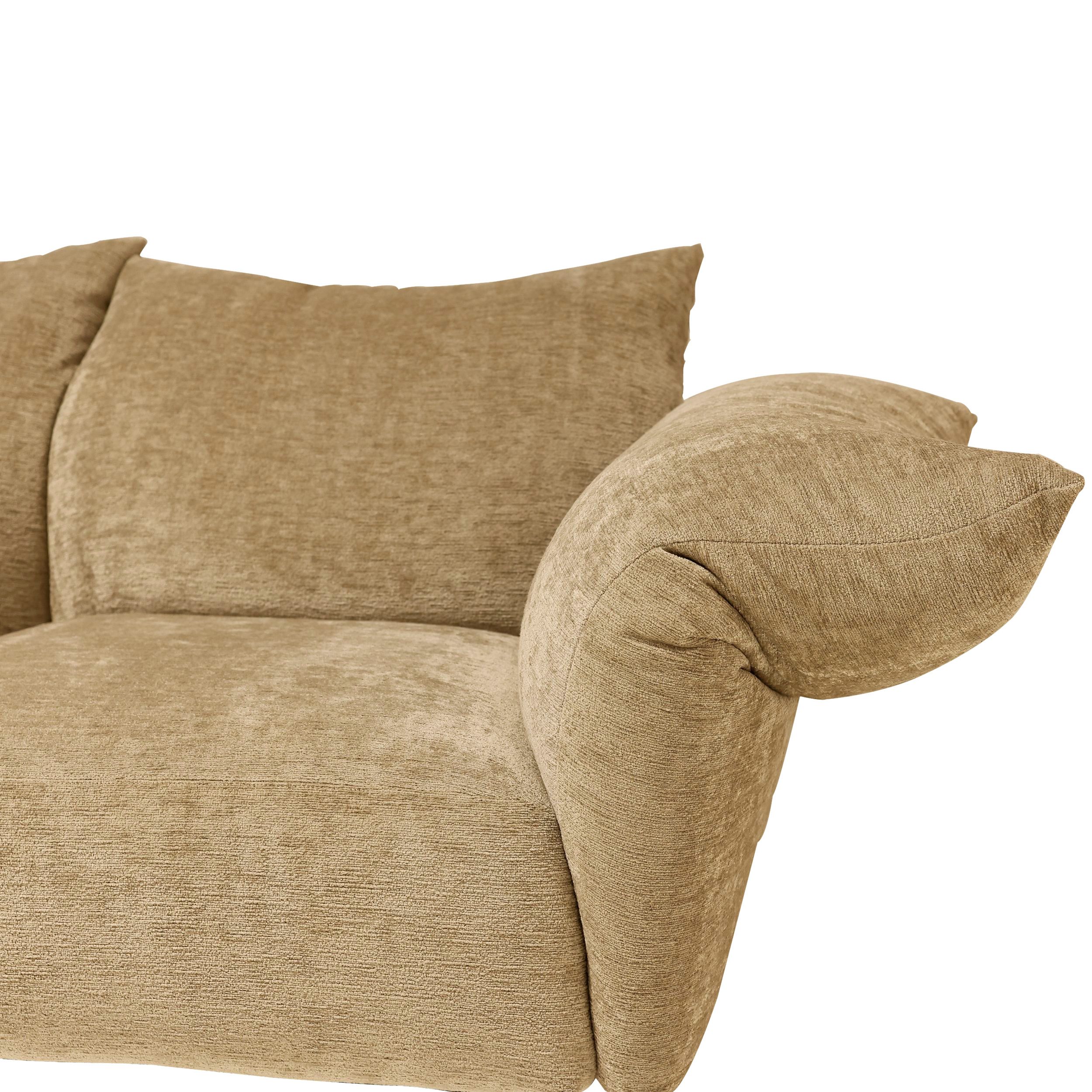 Zu sehen ist  eine Detailaufnahme des Sofas Standard von Edra.
Gezeigt wird ein Abschlusselement mit heruntergeneigeter Armlehne. Das Sofa ist mit sandfarbenem Stoff bezogen und steht vor einem weißen Hintergrund.