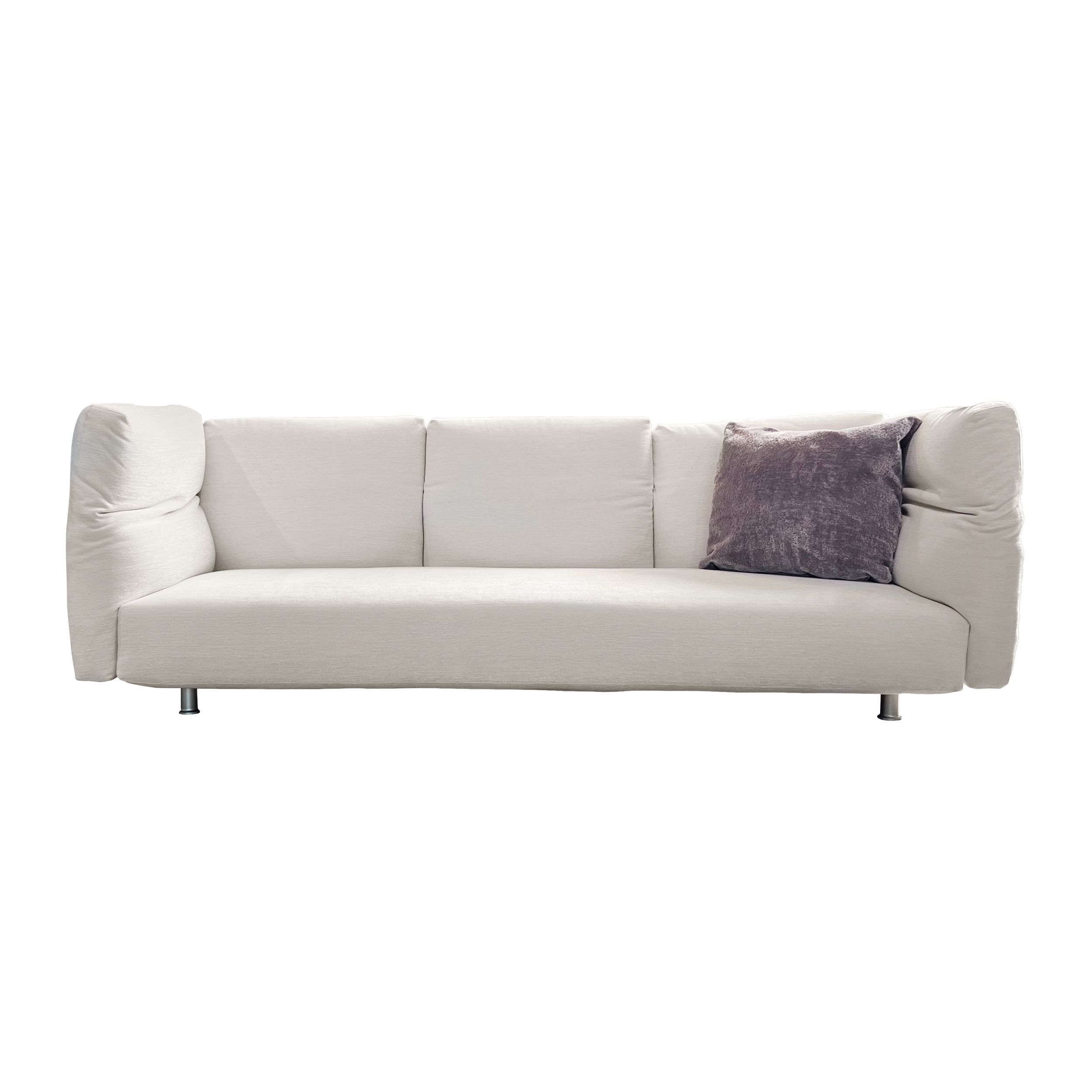 Ein weißes, dreisítziges Stoff-Sofa mit geweglichen Lehnen, Modell Essential von Edra, in frontaler Ansicht vor einem weißen Hintergrund; auf dem Sofa liegt ein graues Kissen, alle Lenen sind aufrecht nach oben gestellt.