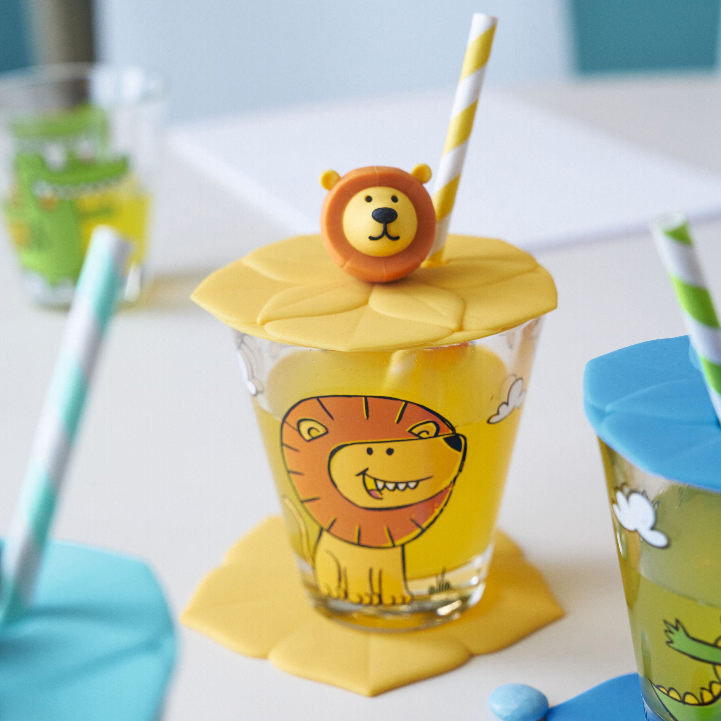 Deckel Bambini mit Löwenkopf von Leonardo gelb auf gefülltem Glas liegend mit Strohhalm