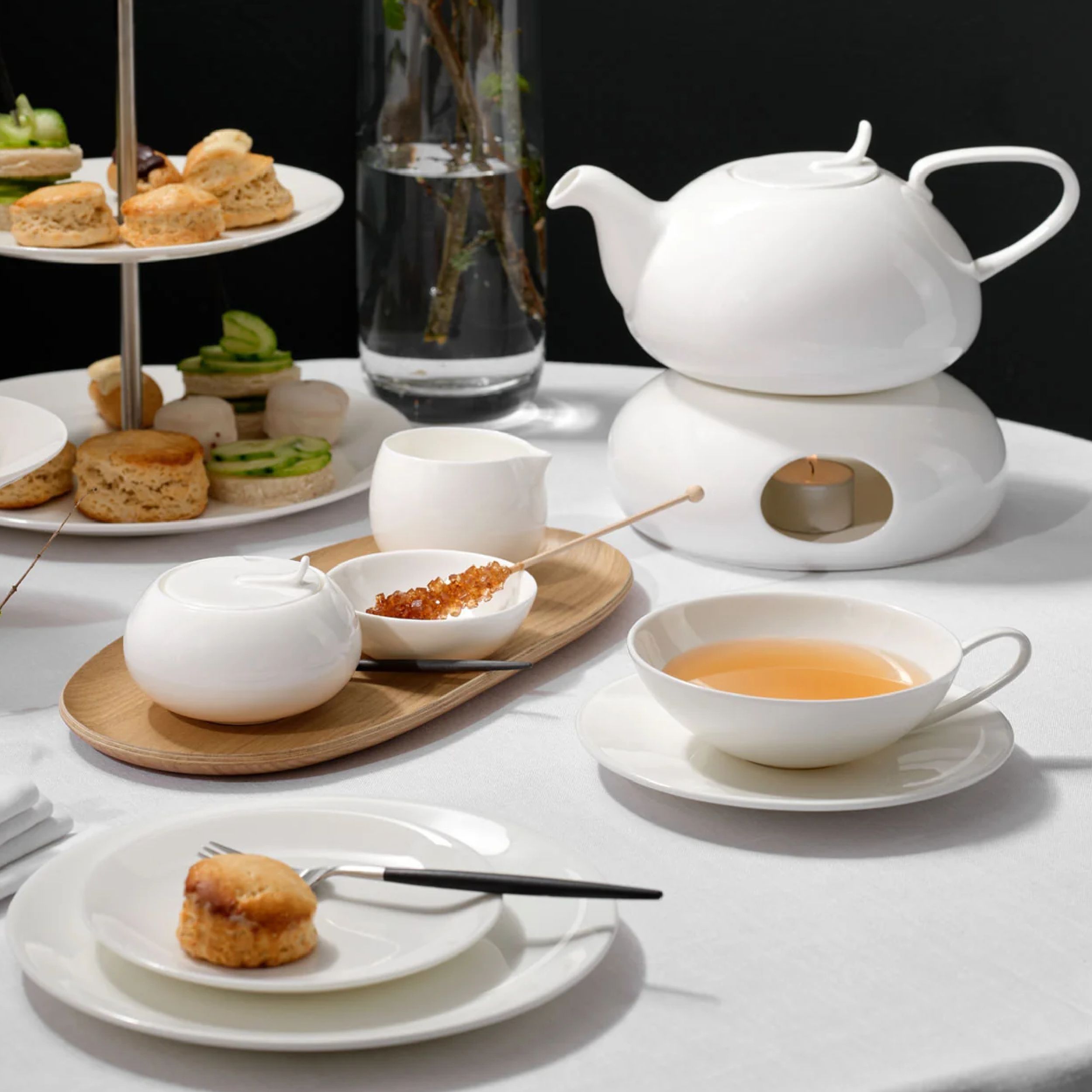Milchkännchen A Table von Asa in weiss auf gedecktem Teetisch vor schwarzem Hintergrund
