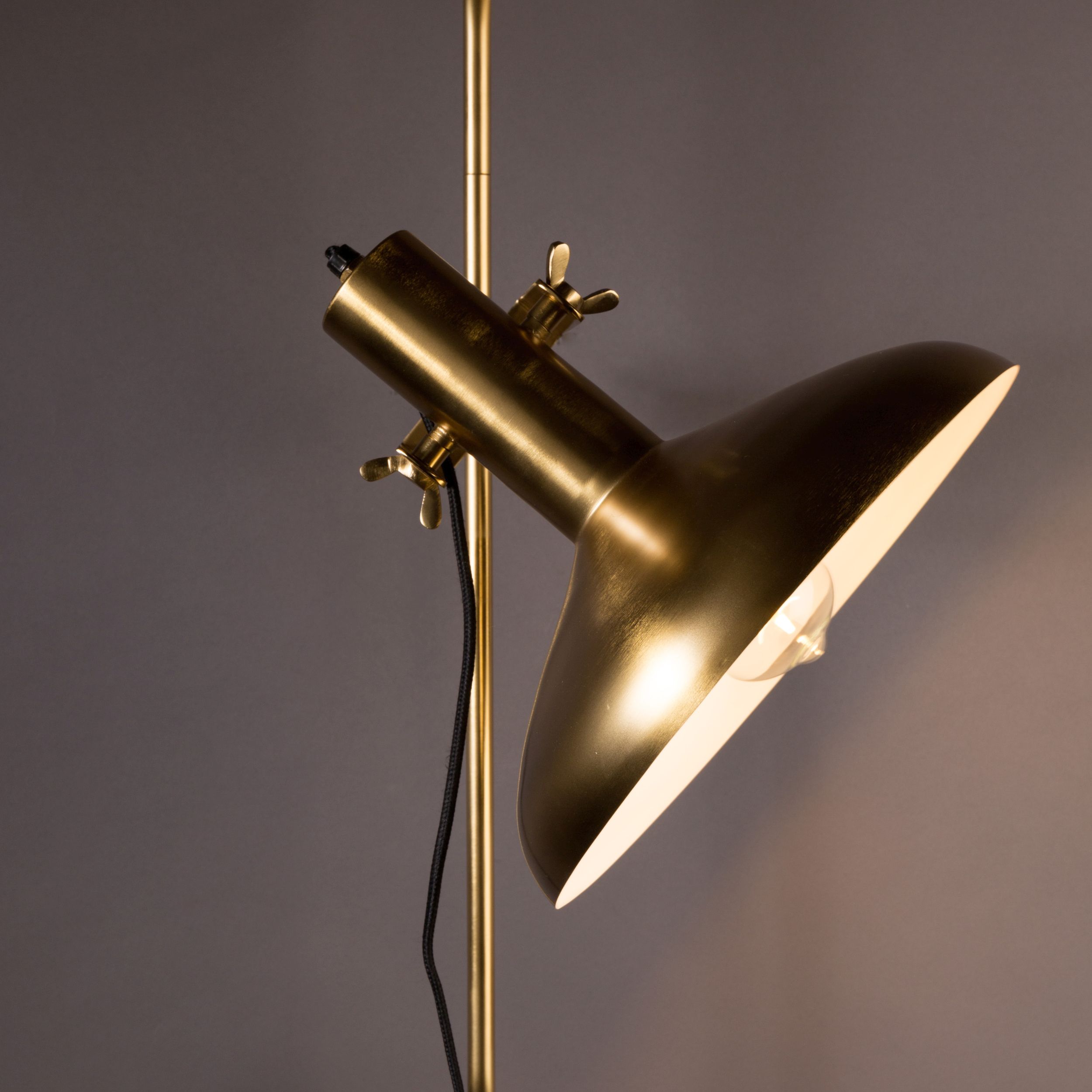 Goldener, trichterförmiger Lampenschirm aus Messing mit warmem Lichtschein.