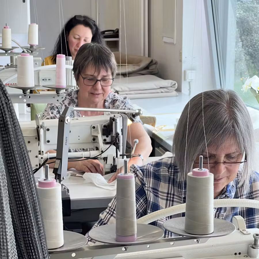 Näherinnen an Nähmaschinen im Atelier der Raumausstattung