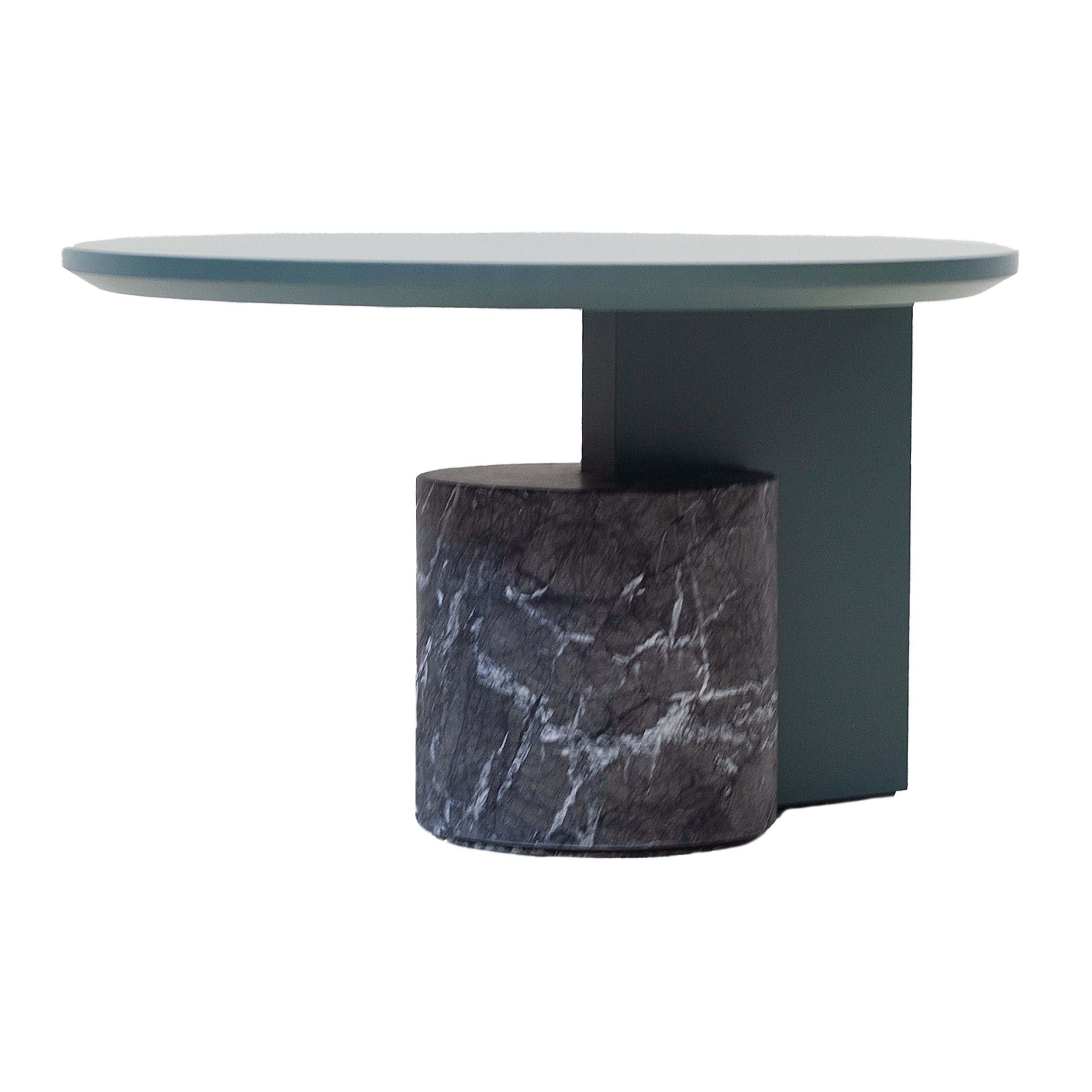 Ein runder Couchtisch, Modell Sengu von Cassina, mit grüner Platte und schwarzem Marmorfuß vor einem weißen Hintergrund.