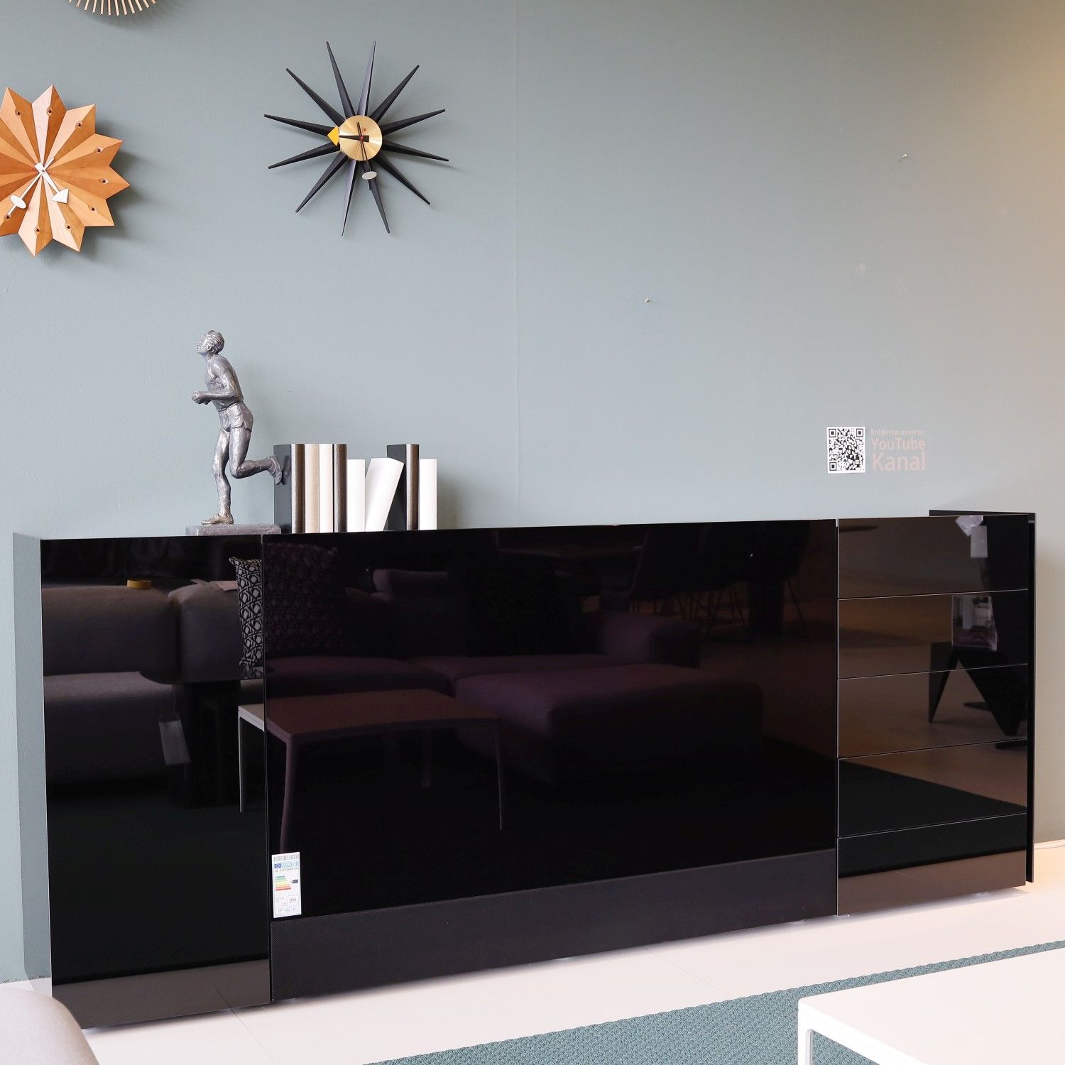 Sideboard Jorel von Interlübke mit integriertem TV in Glas schwarz im Milieubild.