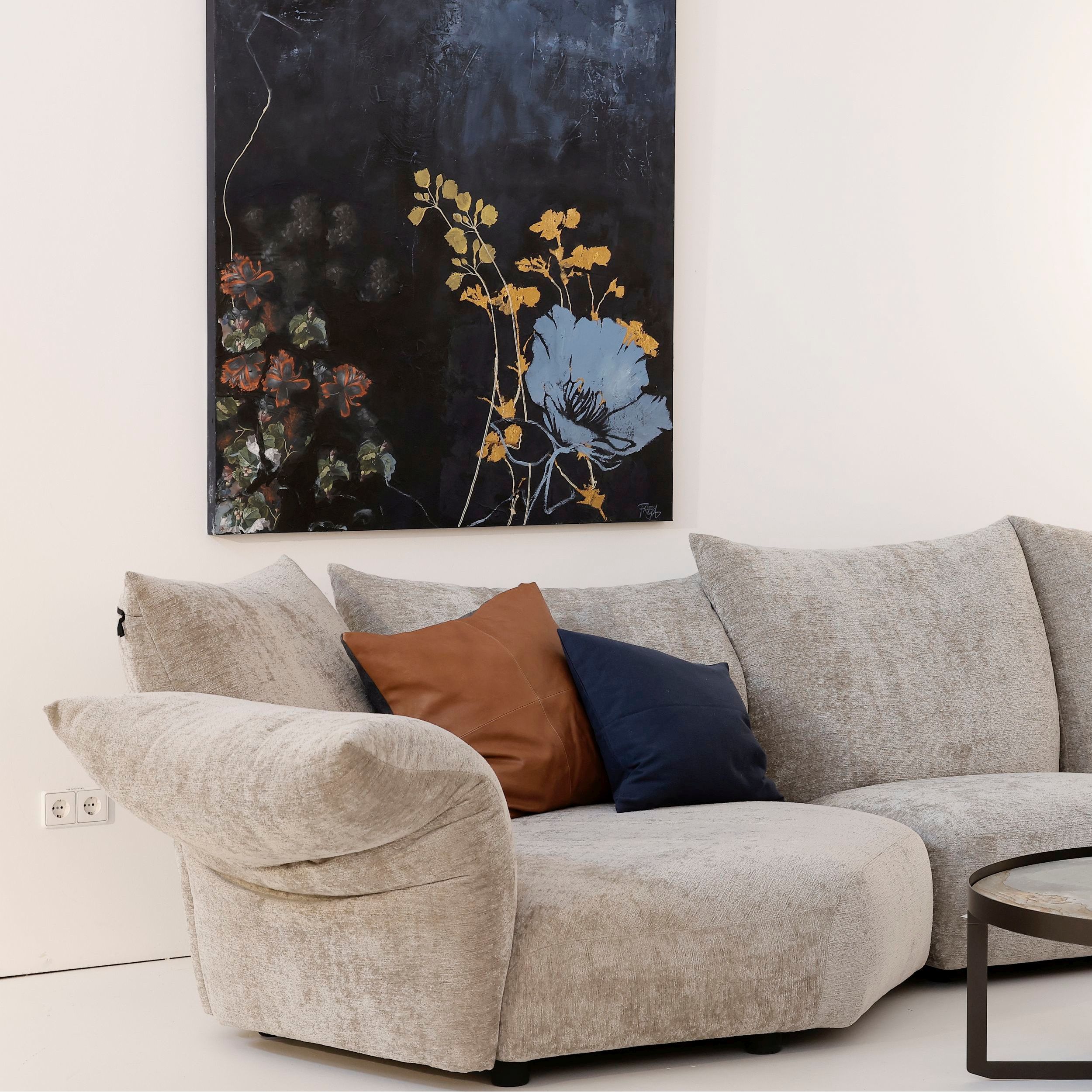 Zu sehen ist das Sofa Standard von Edra in einem eleganten Interieur in hellen Naturtönen und Dekoration in Dunkelblau. Das Bild zeigt die linke Hälfte der Sofakombination mit Liegenelement.