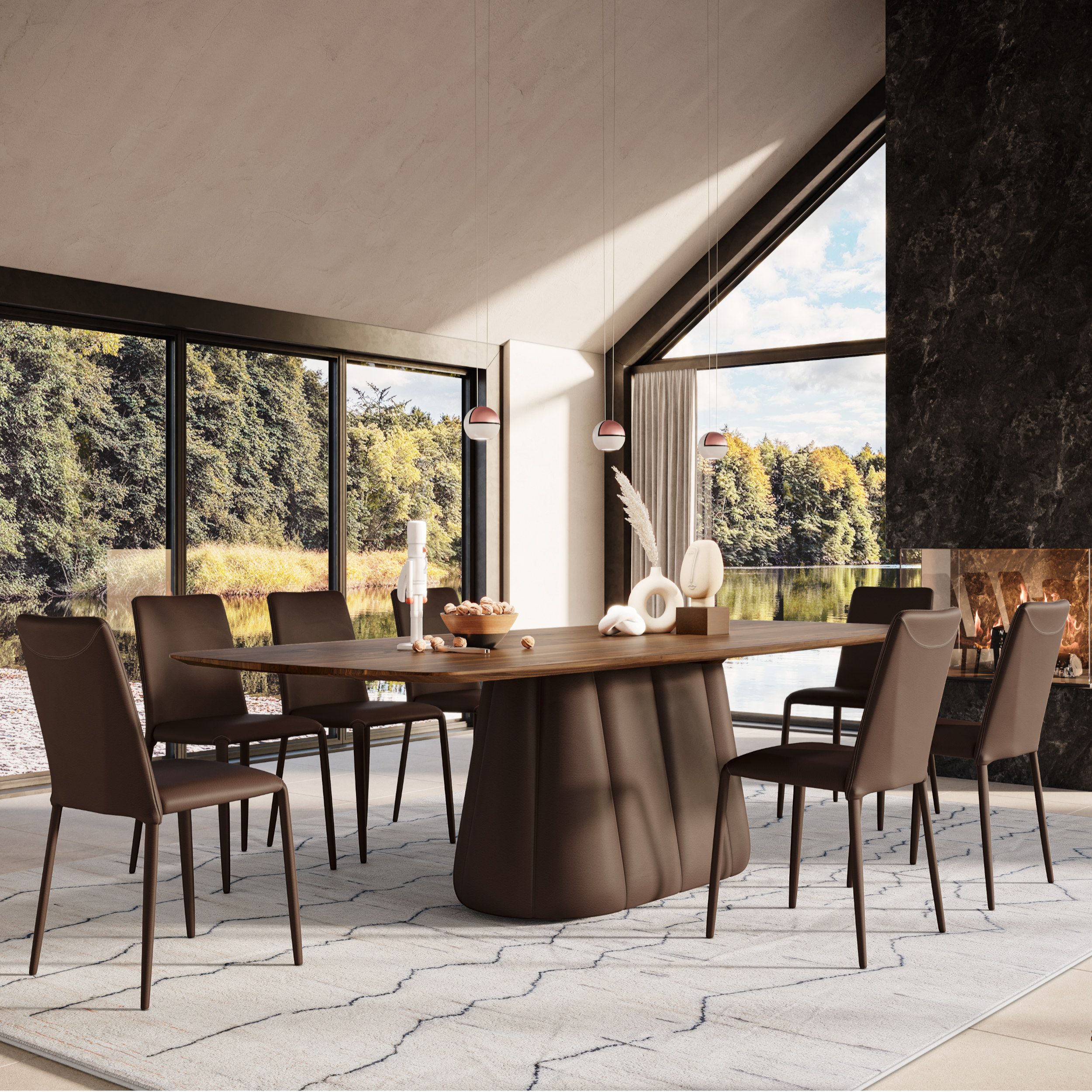 Das Bild zeigt eine elegante Essgruppe, bestehend aus einem großen Tisch mit markantem Zentralfuß und braunen Lederstühlen, vor großen Fensterfronten mit Ausblick ins Grüne. Rechts im Hintergrund sieht man einen offenen Kamin.