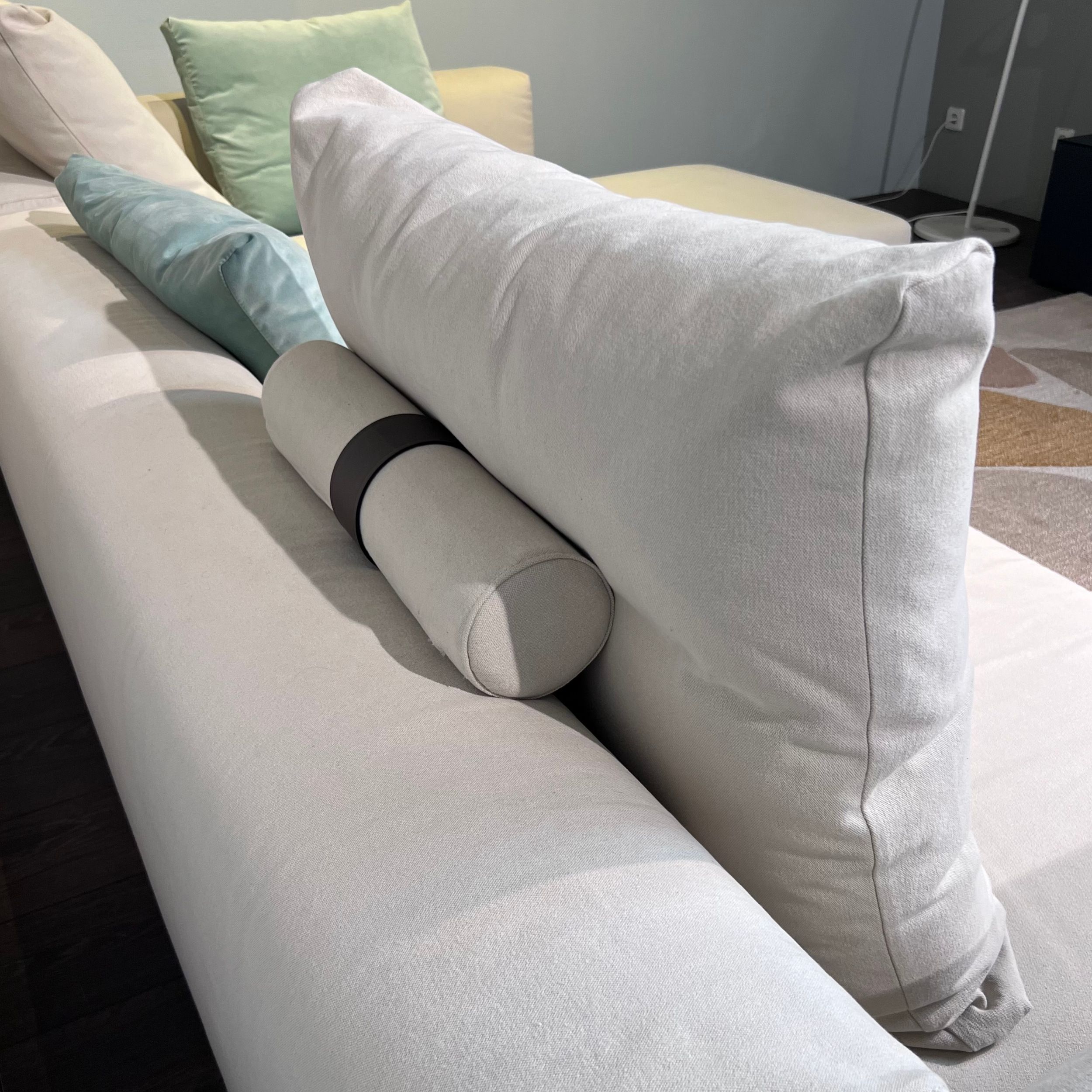 Im Bild sieht man eine Nahaufnahme von der Rückseite des Sofas Lario von Flexform; hinter dem Rückenkissen befindet sich eine zylindrische Polsterrolle.