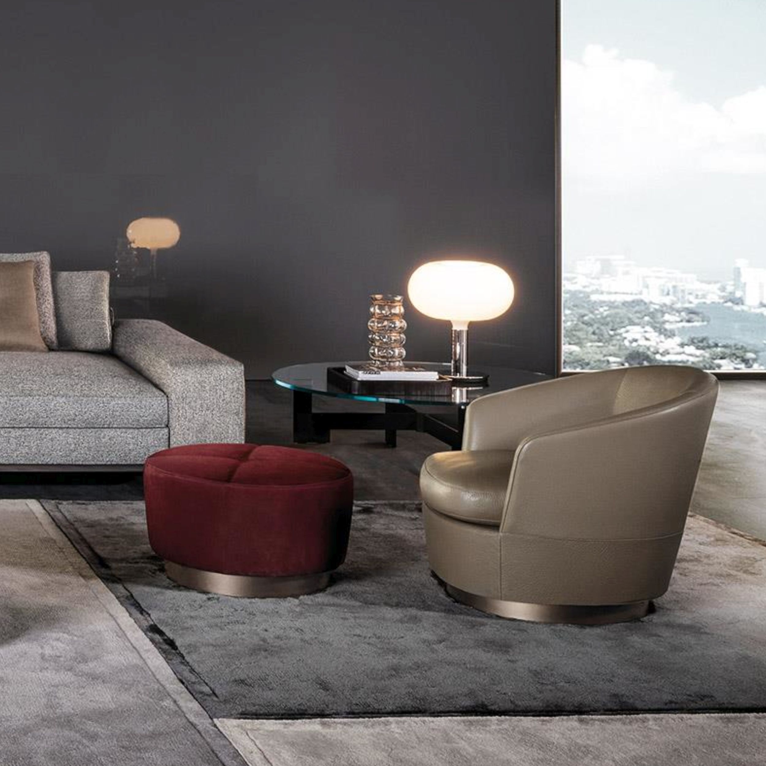 Sessel Jacques von Minotti in braunem Glattleder im Milieubild mit rotem Hocker Jacques.