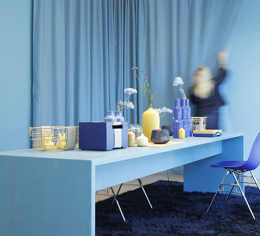 Blauer Tisch mit bunten Dekoartikeln vor einem blauen Vorhang