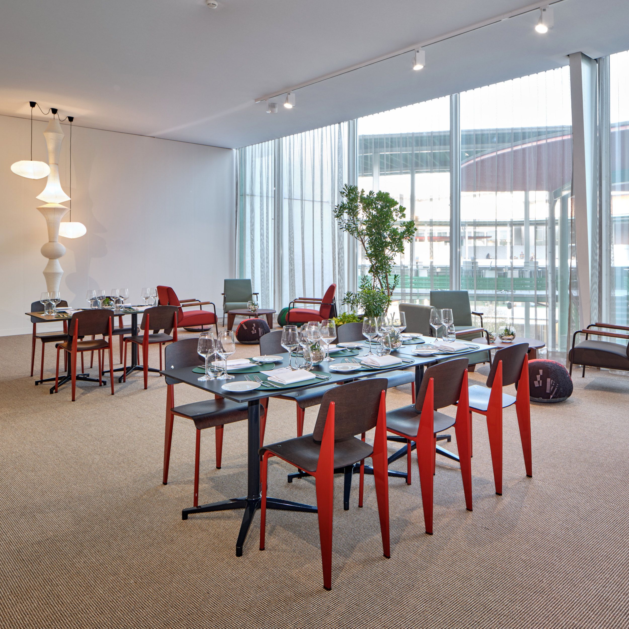 Moderne Tischanordnung mit Stühlen vom Typ Standard SP von Vitra mit rot lackiertem Gestell.