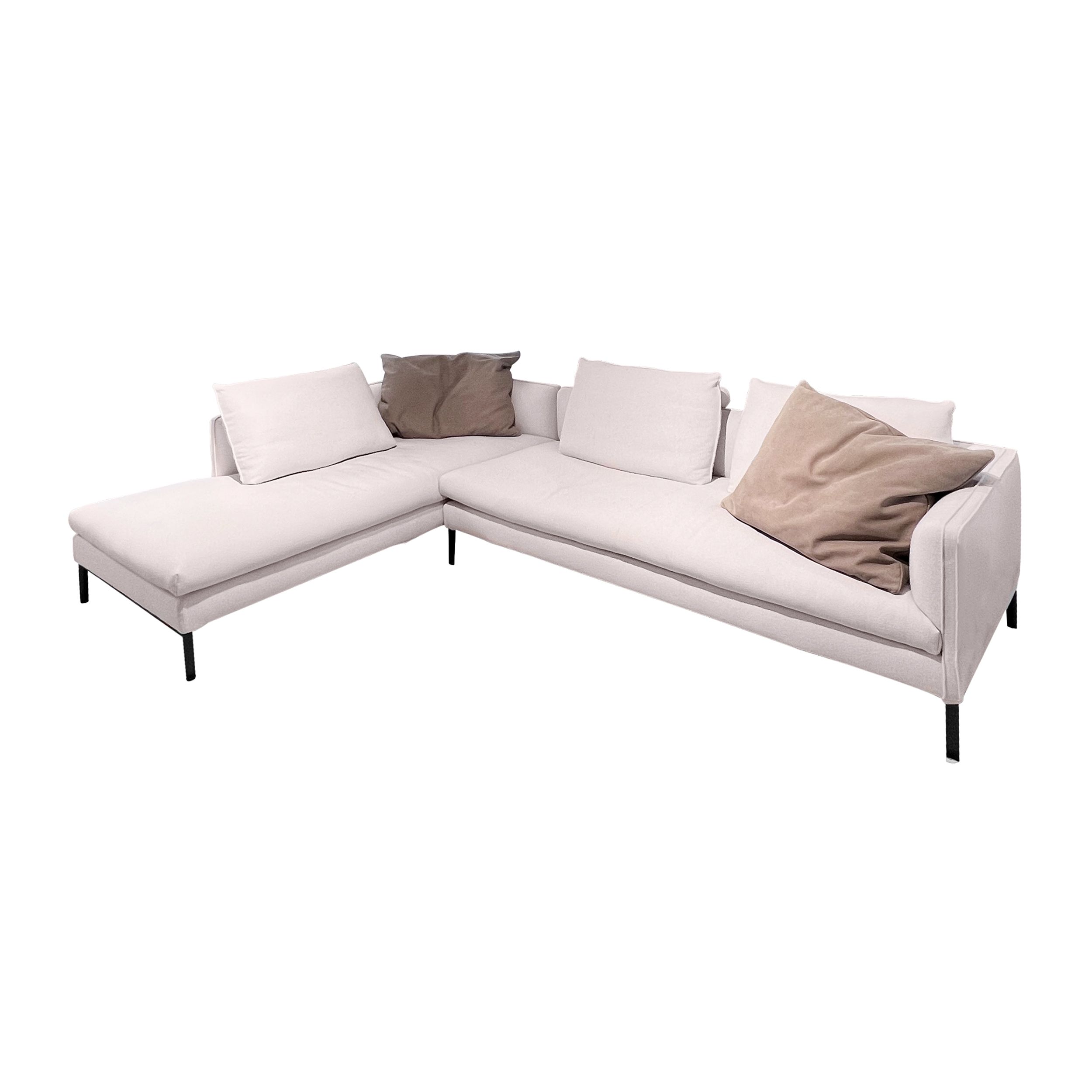 Sofa Paul von Molteni in weißem Stoff mit zwei braunen Leder-Dekokissen als Freisteller.