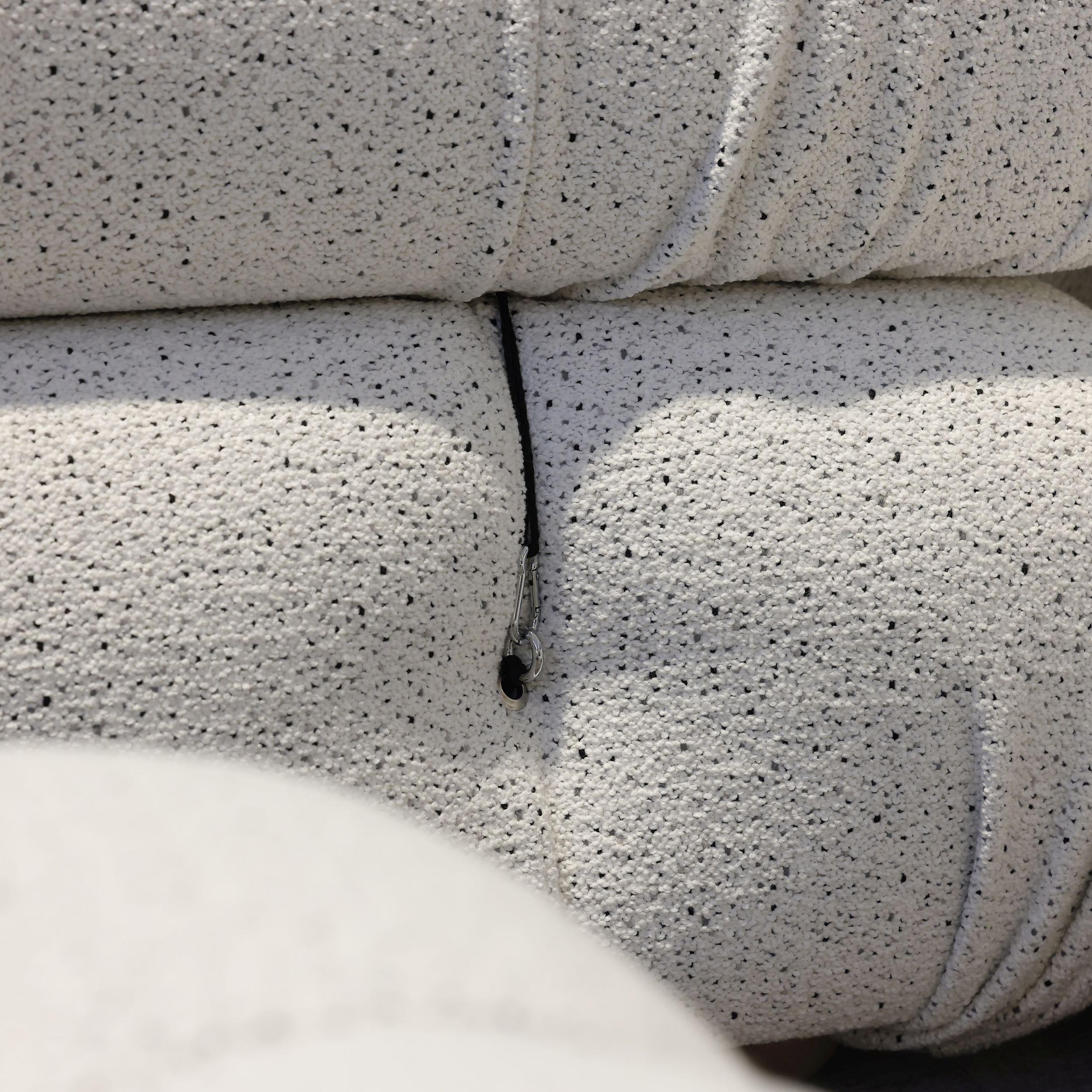 Das Bild zeigt eine Nahaufnahme vom Sofa Camaleonda von B&B Italia; zu sehen ist die Befestigung der Lehne am Sitzelement mittels Karabiner.